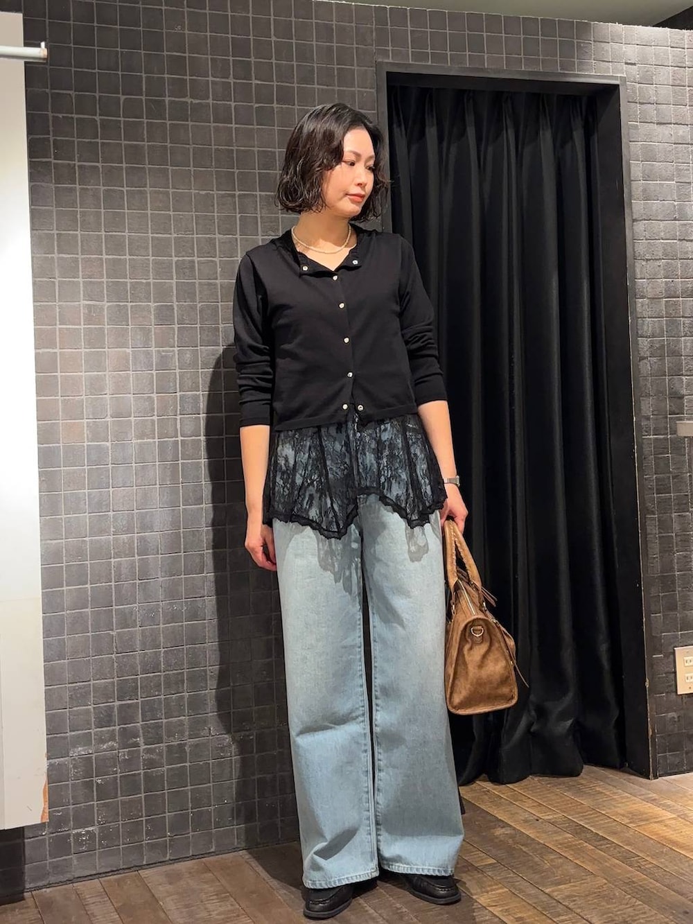 ブラウン系のローファー、ブラウン系のボストンバッグ、ブルー系のデニムパンツを着用したレディースの春コーディネートの2枚目の写真