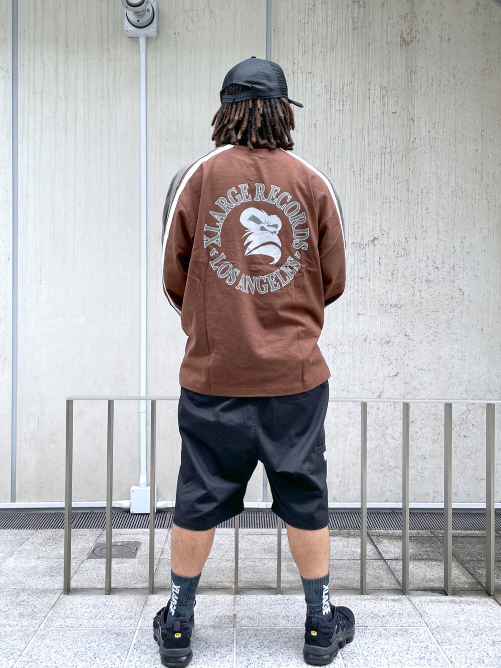 ブラウン系のTシャツ/カットソー、ブラック系のキャップを着用したメンズの夏コーディネートの2枚目の写真