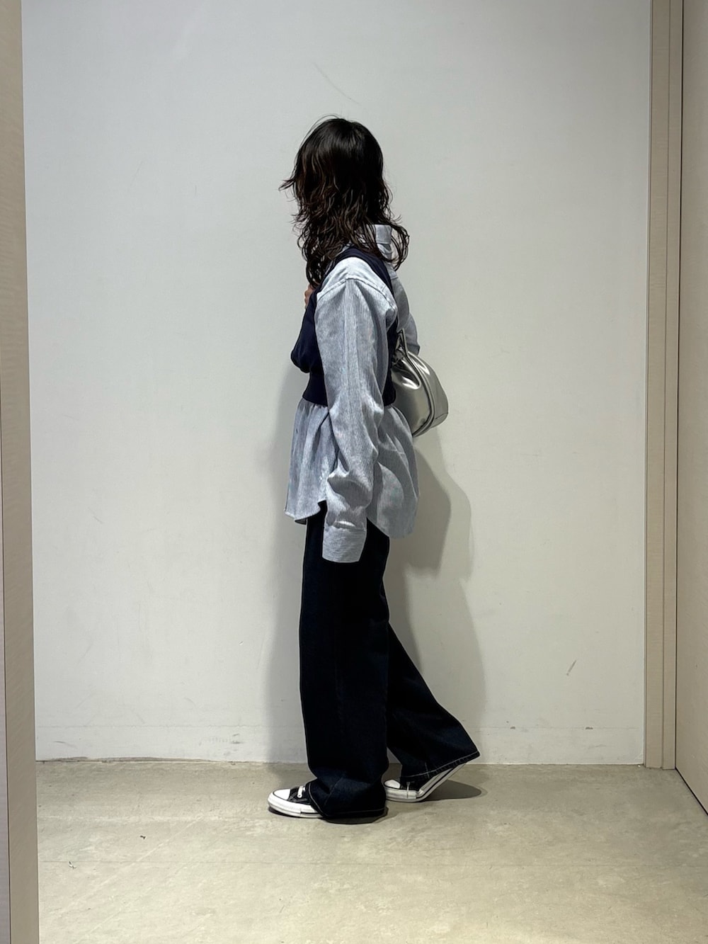 ブルー系のシャツ/ブラウス、ブルー系のデニムパンツ、シルバー系のショルダーバッグを着用したレディースの春コーディネートの2枚目の写真