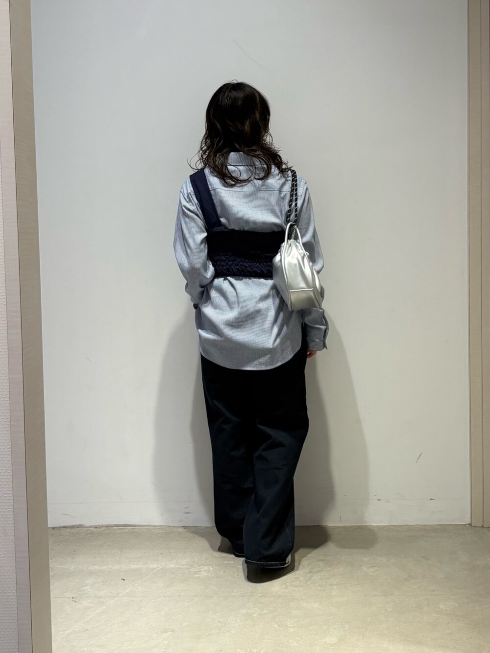 ブルー系のシャツ/ブラウス、ブルー系のデニムパンツ、シルバー系のショルダーバッグを着用したレディースの春コーディネートの3枚目の写真