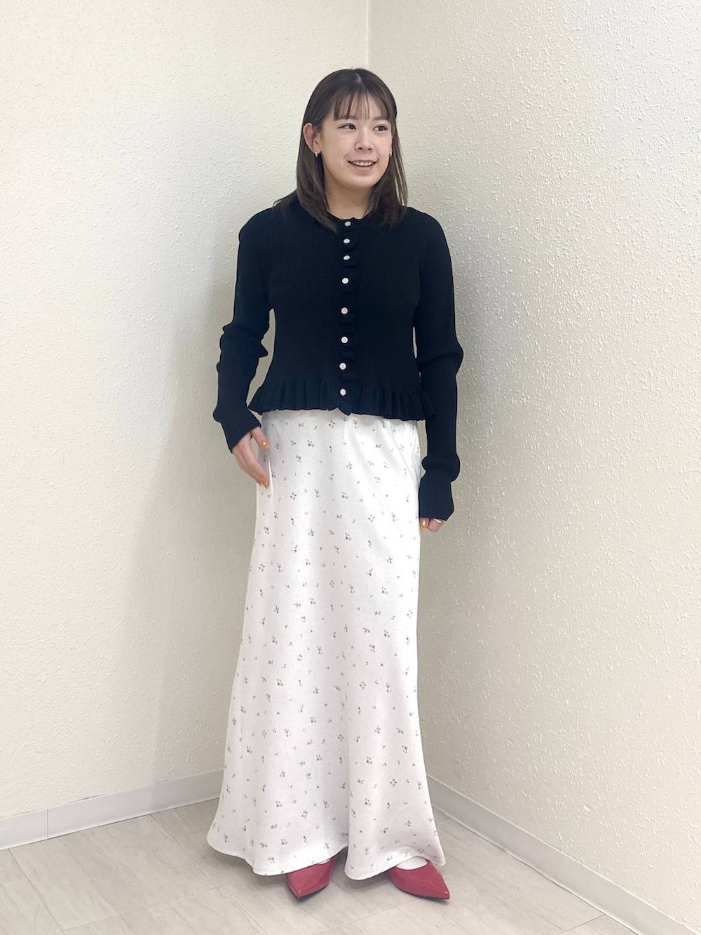 ホワイト系のスカート、レッド系のパンプス、ブラック系のTシャツ/カットソーを着用したレディースの春コーディネートの2枚目の写真