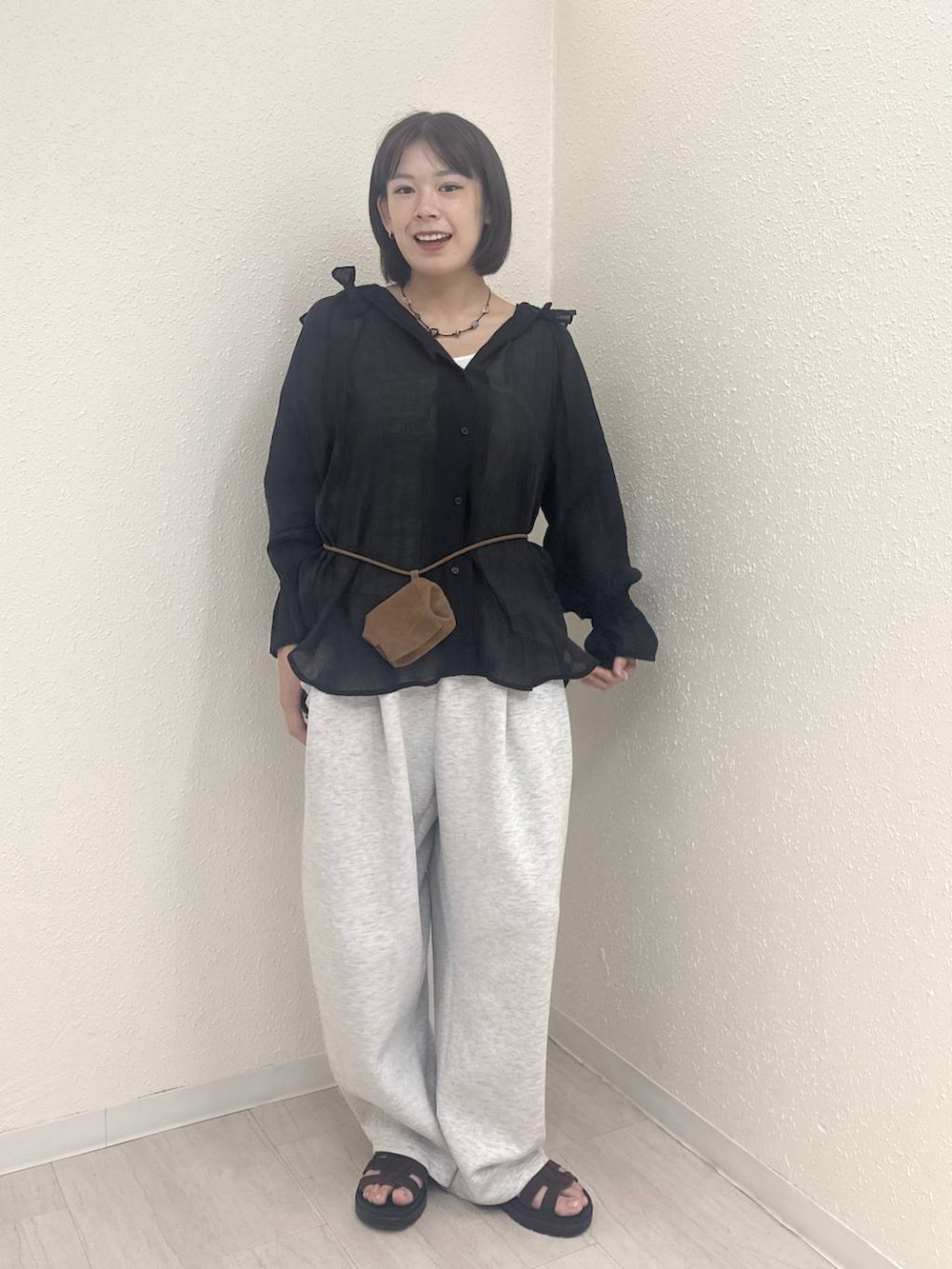 イエロー系のボディバッグ/ウエストポーチ、グレー系のスウェットパンツ、ブラック系のシャツ/ブラウスを着用したレディースの秋コーディネートの2枚目の写真