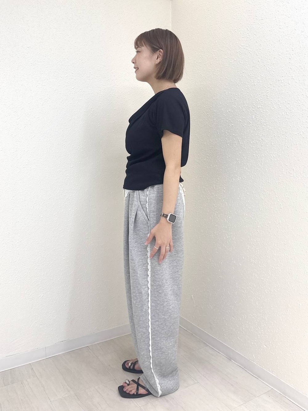 ブラック系のTシャツ/カットソー、グレー系のスウェットパンツ、ブラック系のサンダルを着用したレディースの夏コーディネートの3枚目の写真