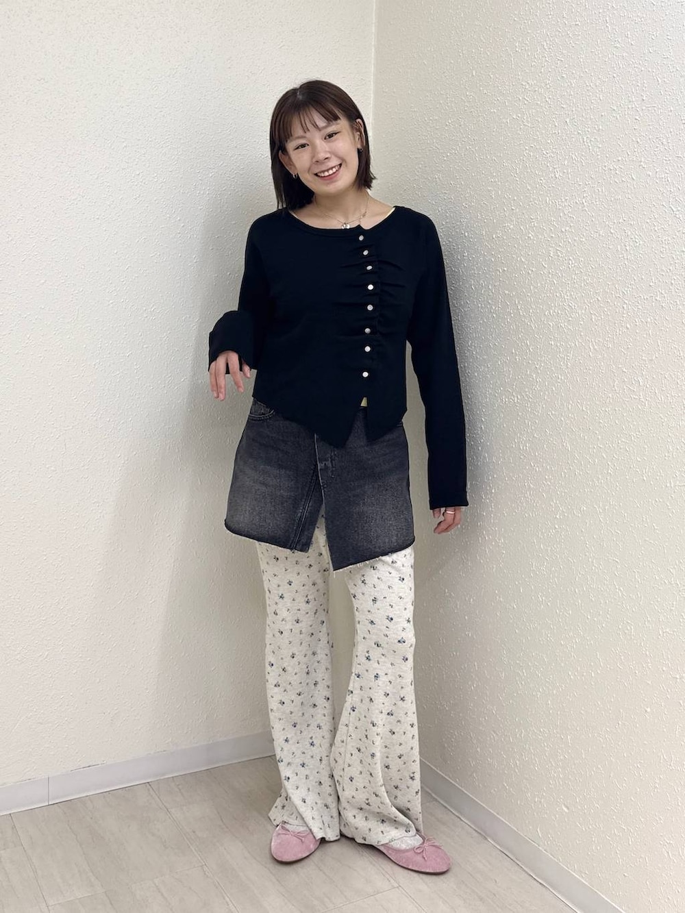 ブラック系のデニムパンツ、ピンク系のバレエシューズ、ブラック系のニット/セーターを着用したレディースの秋コーディネートの2枚目の写真