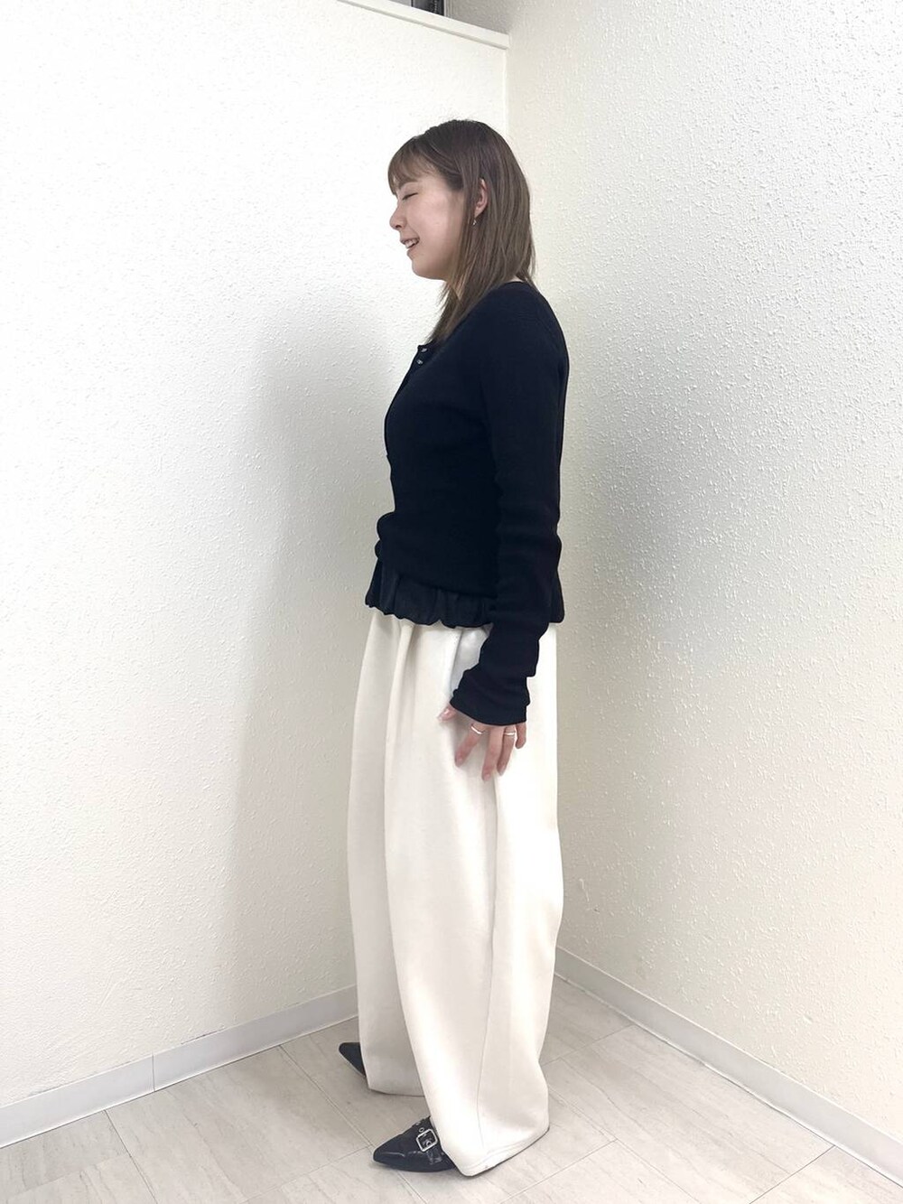 ベージュ系のスウェットパンツ、ブラック系のニット/セーター、ブラック系のTシャツ/カットソーを着用したレディースの春コーディネートの3枚目の写真