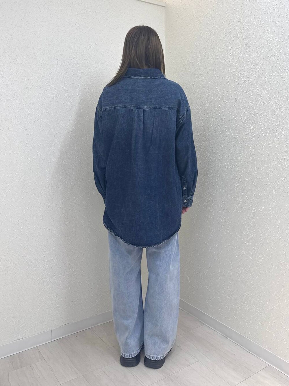 ブルー系のデニムパンツ、ブルー系のシャツ/ブラウス、ブラウン系のローファーを着用したレディースの冬コーディネートの4枚目の写真