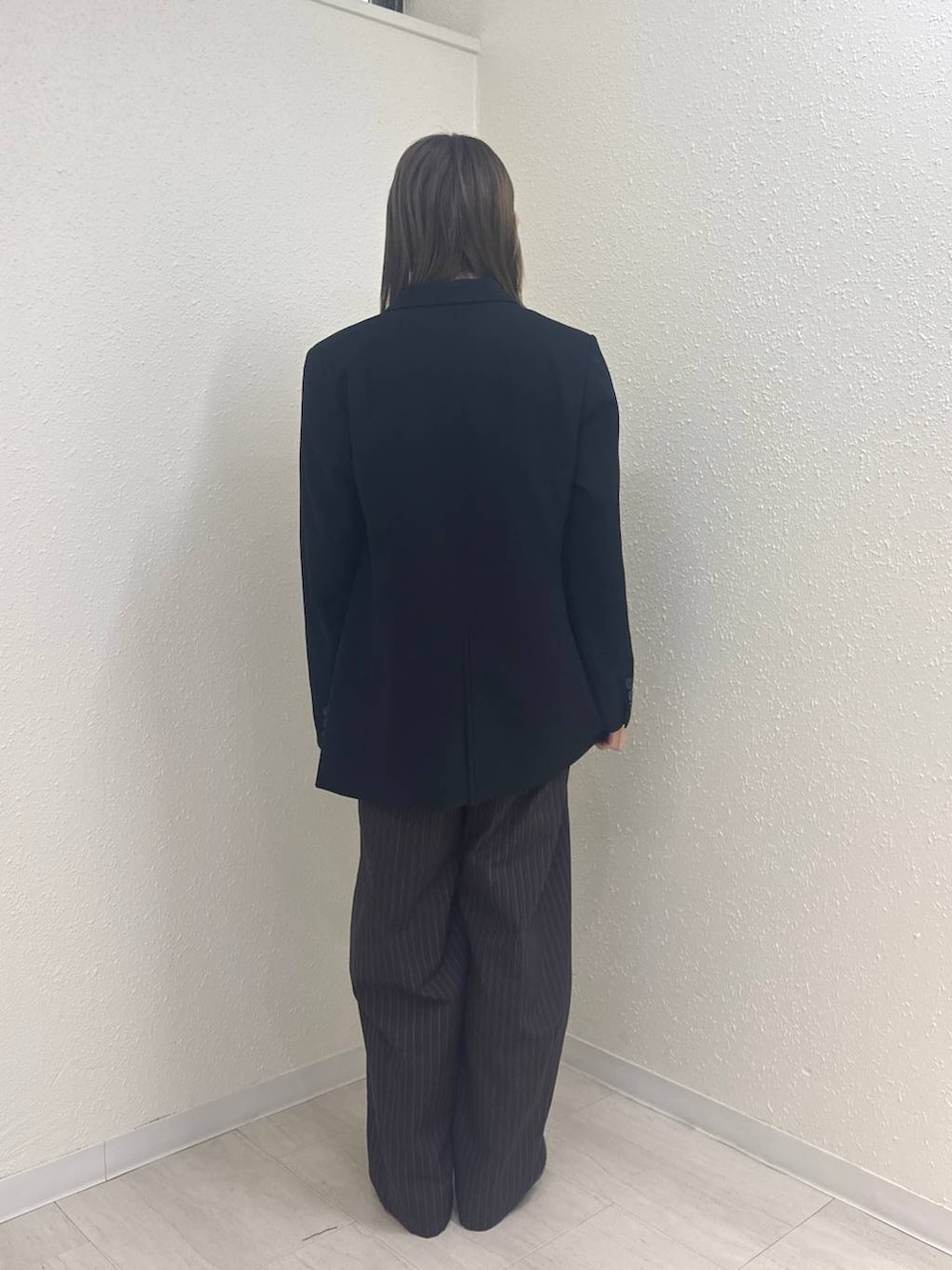 ブルー系のその他パンツ、ブラック系のパンプス、ブラック系のテーラードジャケットを着用したレディースの冬コーディネートの3枚目の写真