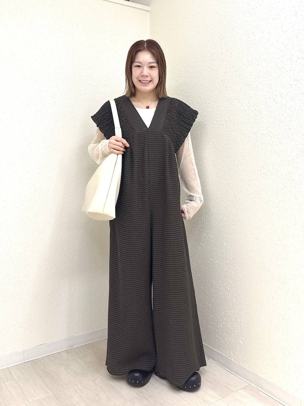 ホワイト系のショルダーバッグ、ブラウン系のサロペット/オーバーオール、ブラック系のサンダルを着用したレディースの春コーディネートの3枚目の写真