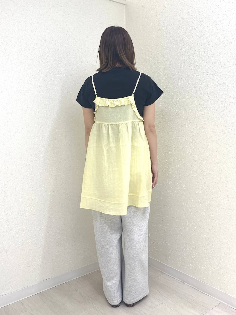 グレー系のスウェットパンツ、ブラック系のTシャツ/カットソー、イエロー系のキャミソールを着用したレディースの春コーディネートの2枚目の写真
