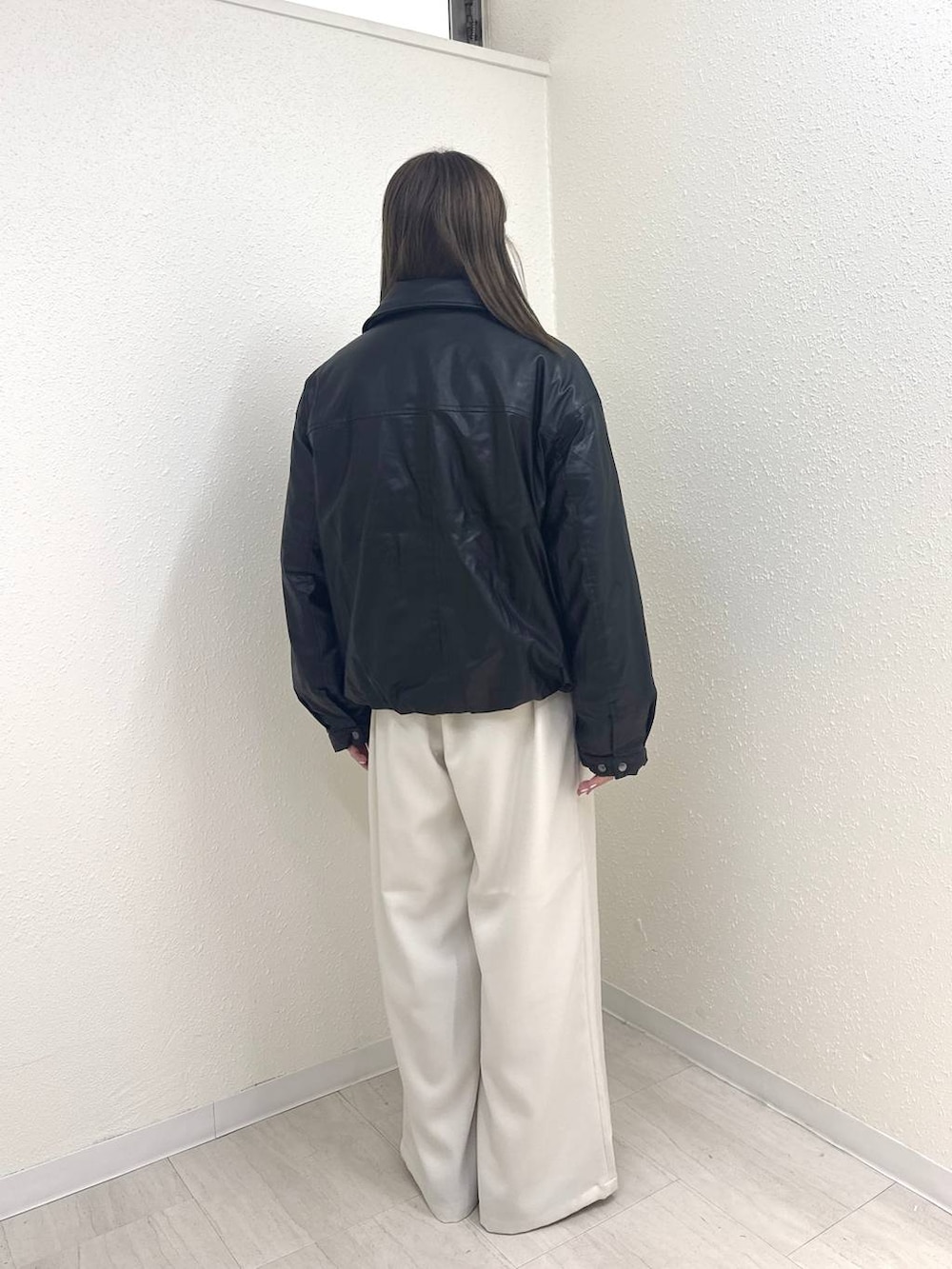 ブラック系のブルゾン、ホワイト系のその他パンツ、ブラック系のモカシン/デッキシューズを着用したレディースの冬コーディネートの3枚目の写真