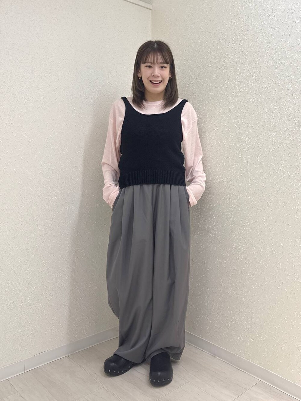 グレー系のその他パンツ、ピンク系のTシャツ/カットソー、ブラック系のサンダルを着用したレディースの春コーディネートの2枚目の写真