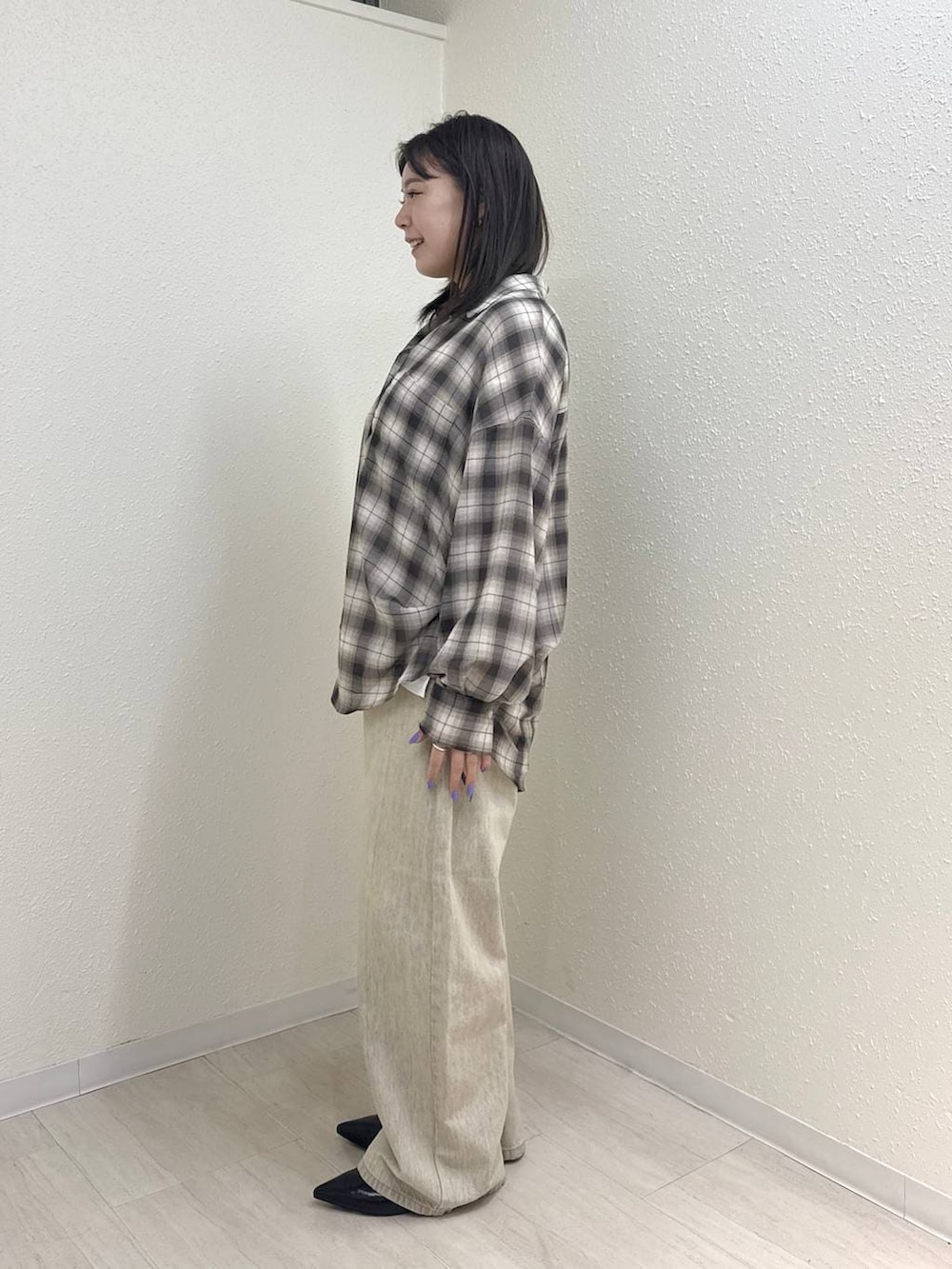 ホワイト系のTシャツ/カットソー、ブラック系のパンプス、ベージュ系のデニムパンツを着用したレディースの春コーディネートの3枚目の写真