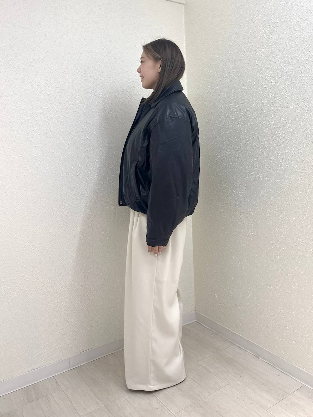 ブラック系のブルゾン、ホワイト系のその他パンツ、ブラック系のモカシン/デッキシューズを着用したレディースの冬コーディネートの4枚目の写真