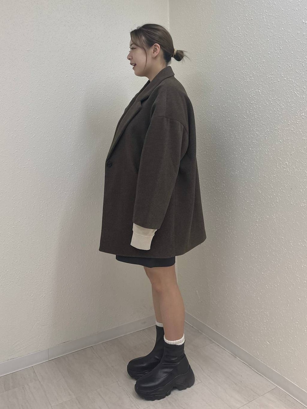 ブラック系のブーツ、ブラウン系のその他アウター、グレー系のその他パンツを着用したレディースの冬コーディネートの3枚目の写真