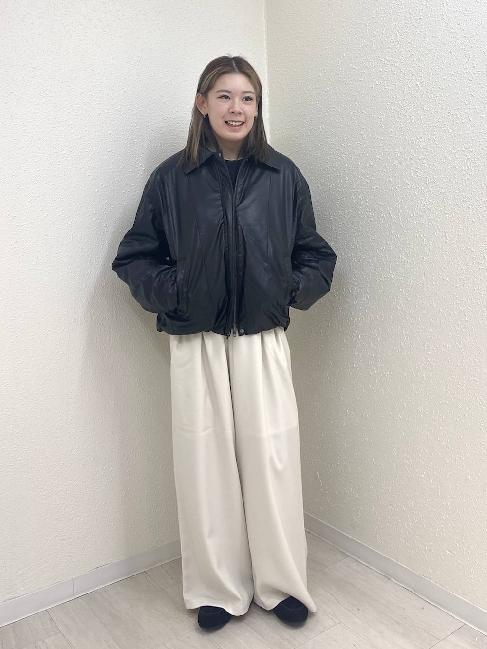 ブラック系のブルゾン、ホワイト系のその他パンツ、ブラック系のモカシン/デッキシューズを着用したレディースの冬コーディネートの2枚目の写真