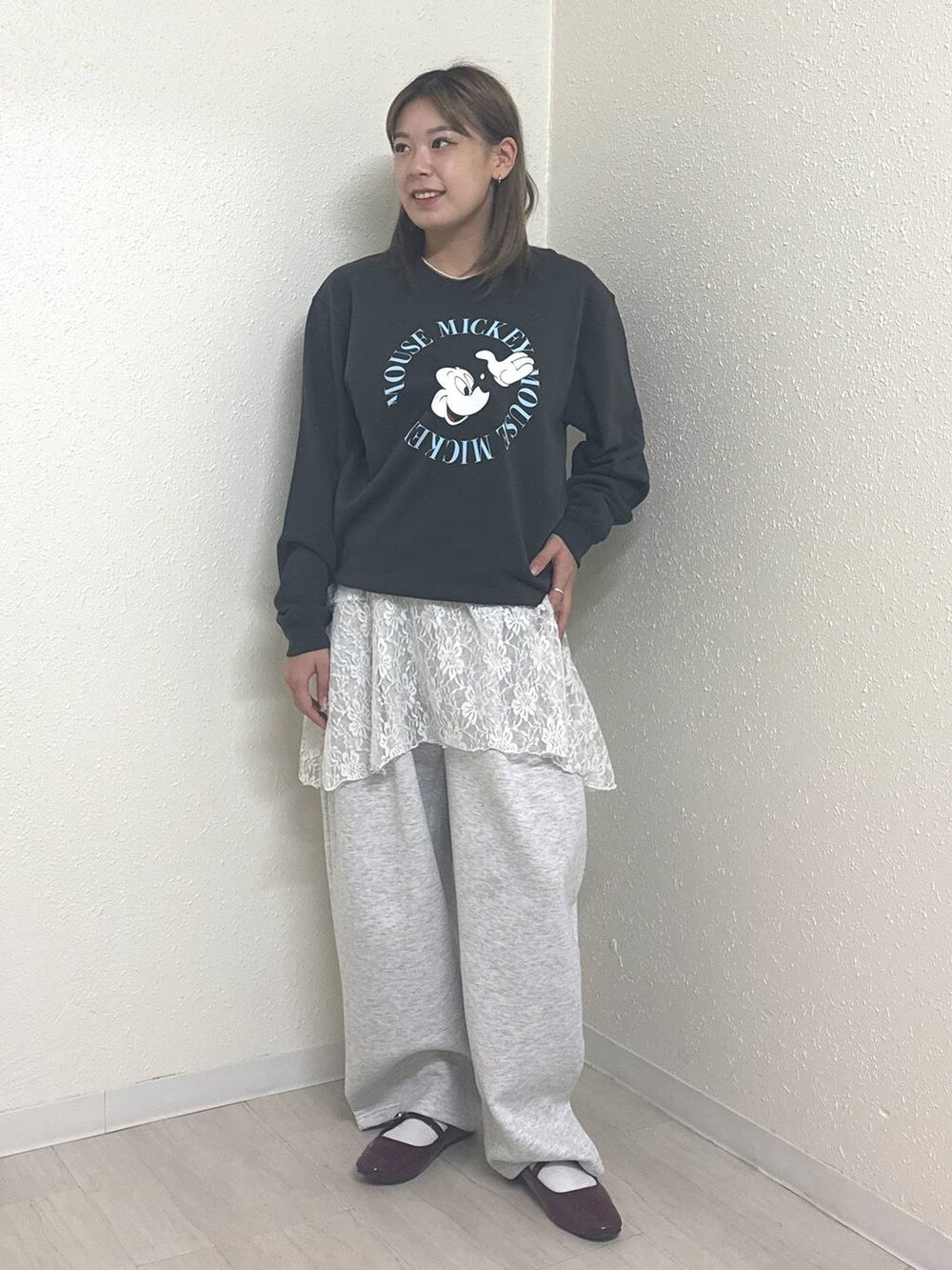 グレー系のスウェットパンツ、ホワイト系のスカート、グレー系のスウェットを着用したレディースの秋コーディネートの2枚目の写真