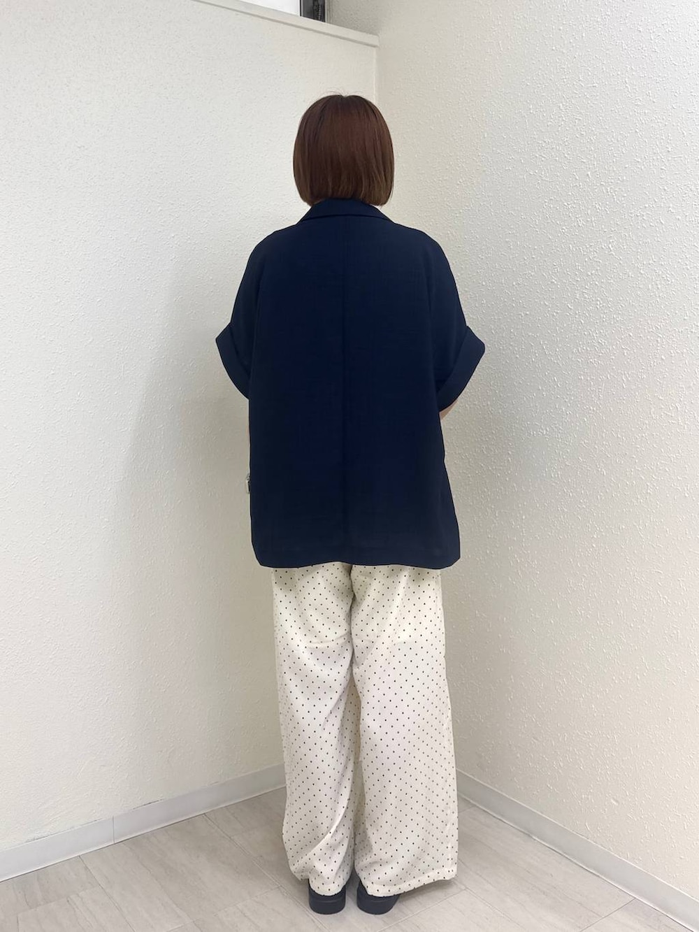 ブルー系のテーラードジャケット、ブラウン系のサンダル、ブラウン系のタンクトップを着用したレディースの夏コーディネートの4枚目の写真
