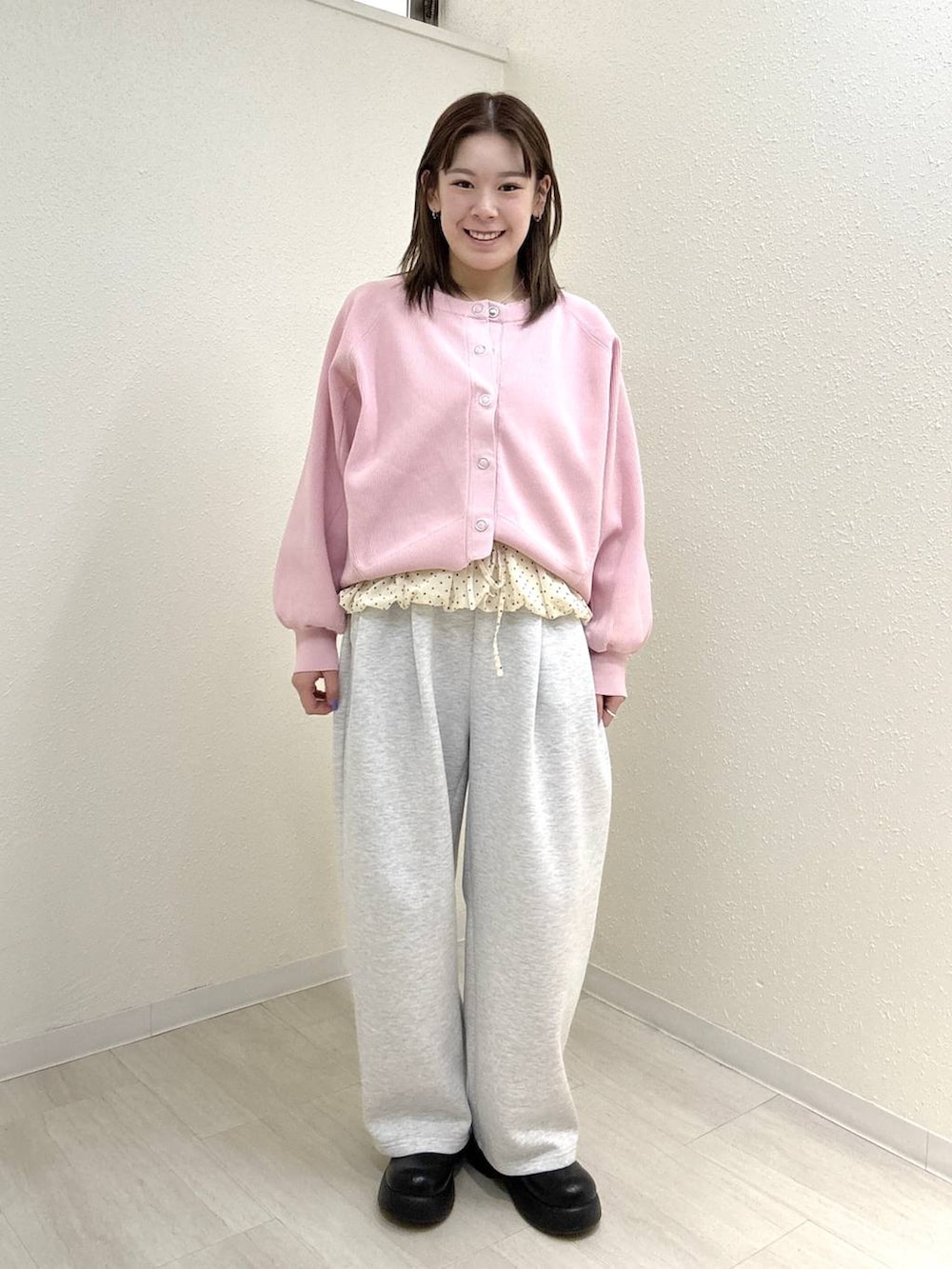 グレー系のスウェットパンツ、ピンク系のカーディガン/ボレロ、ホワイト系のTシャツ/カットソーを着用したレディースの春コーディネートの2枚目の写真