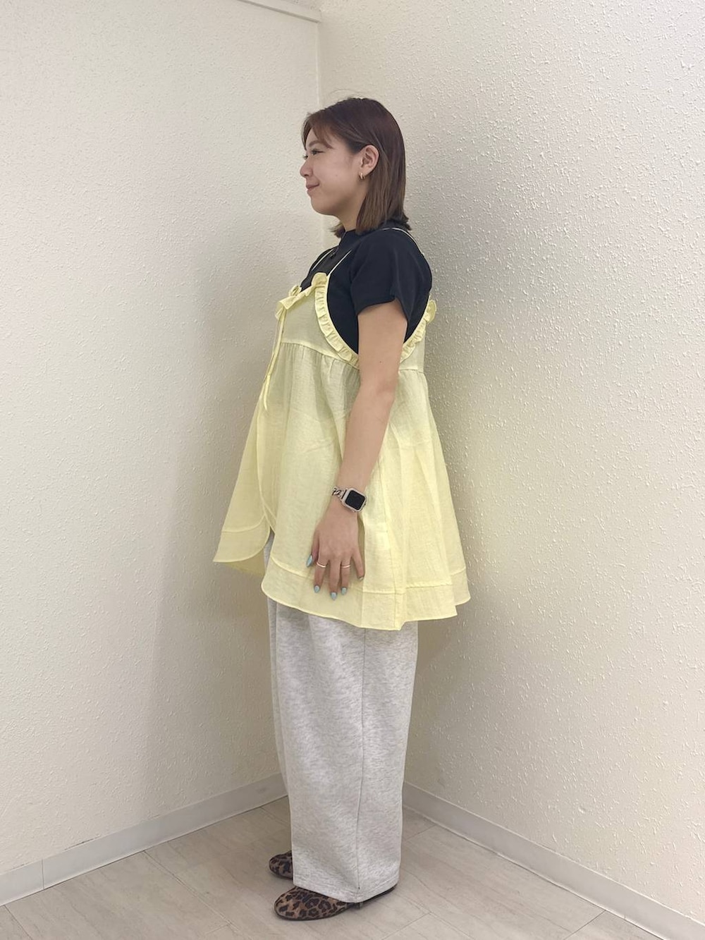 グレー系のスウェットパンツ、ブラック系のTシャツ/カットソー、イエロー系のキャミソールを着用したレディースの春コーディネートの4枚目の写真
