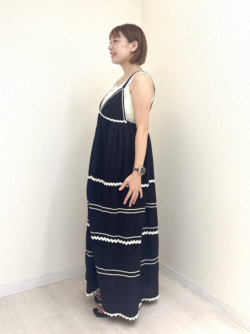 ブラック系のサンダル、ホワイト系のタンクトップ、ブラック系のワンピースを着用したレディースの夏コーディネートの3枚目の写真