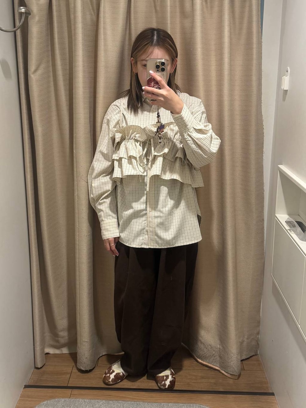 ブラウン系のキャミソール、ベージュ系のシャツ/ブラウスを着用したレディースの冬コーディネートの2枚目の写真