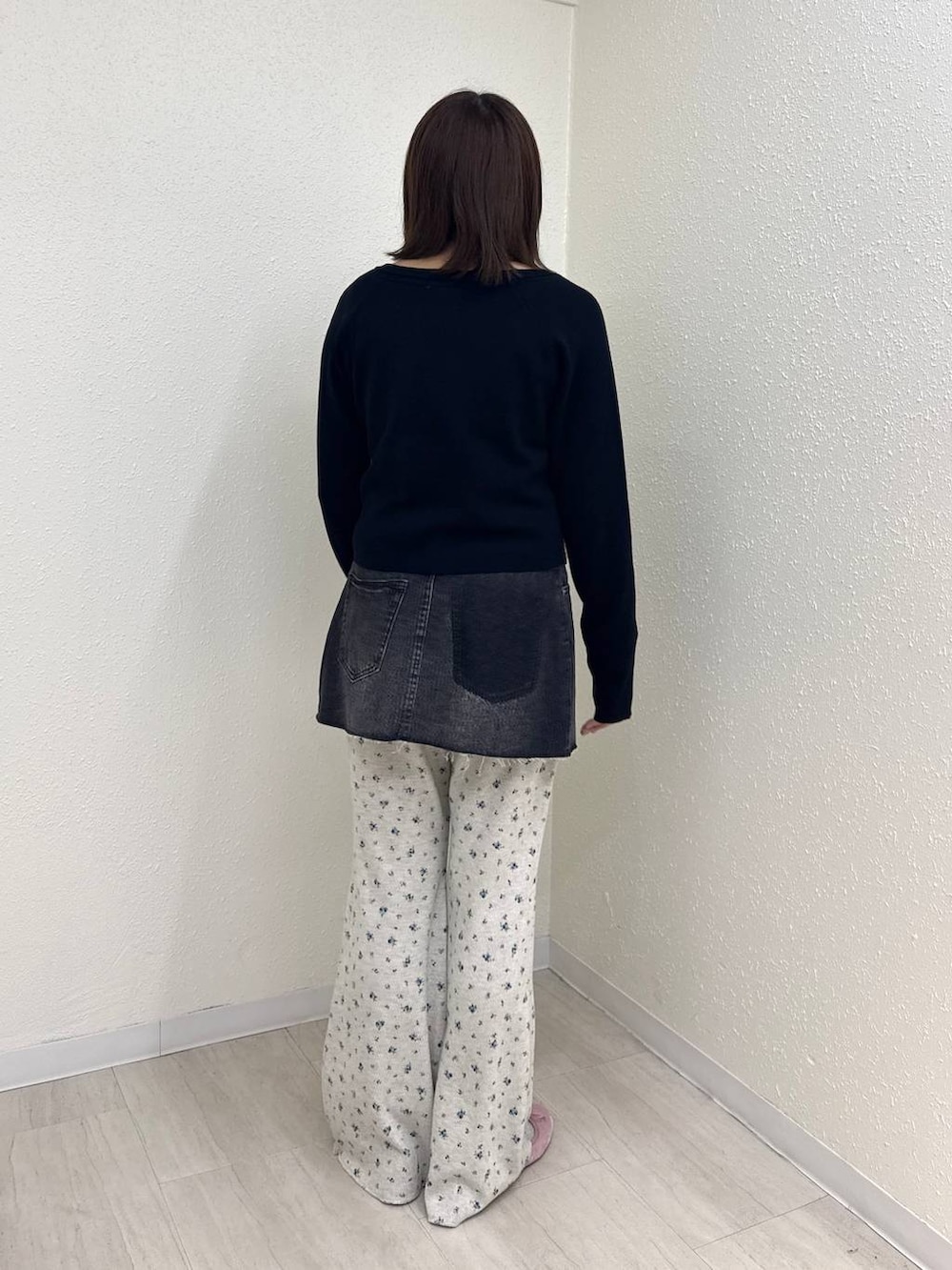 ブラック系のデニムパンツ、ピンク系のバレエシューズ、ブラック系のニット/セーターを着用したレディースの秋コーディネートの4枚目の写真