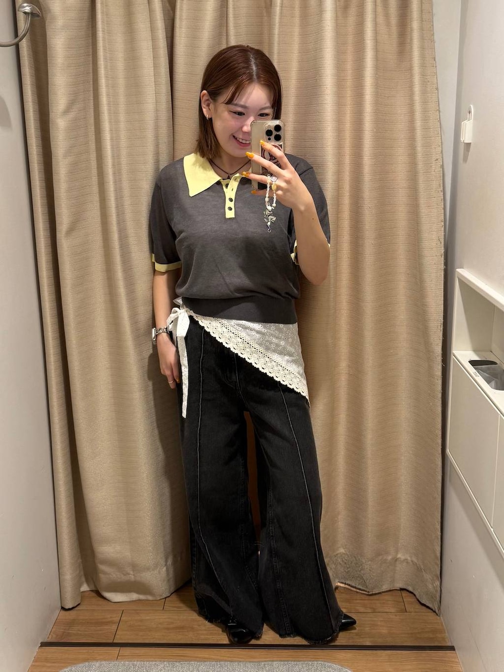 ブラック系のデニムパンツ、ブラック系のサンダル、グレー系のポロシャツを着用したレディースの春コーディネートの2枚目の写真