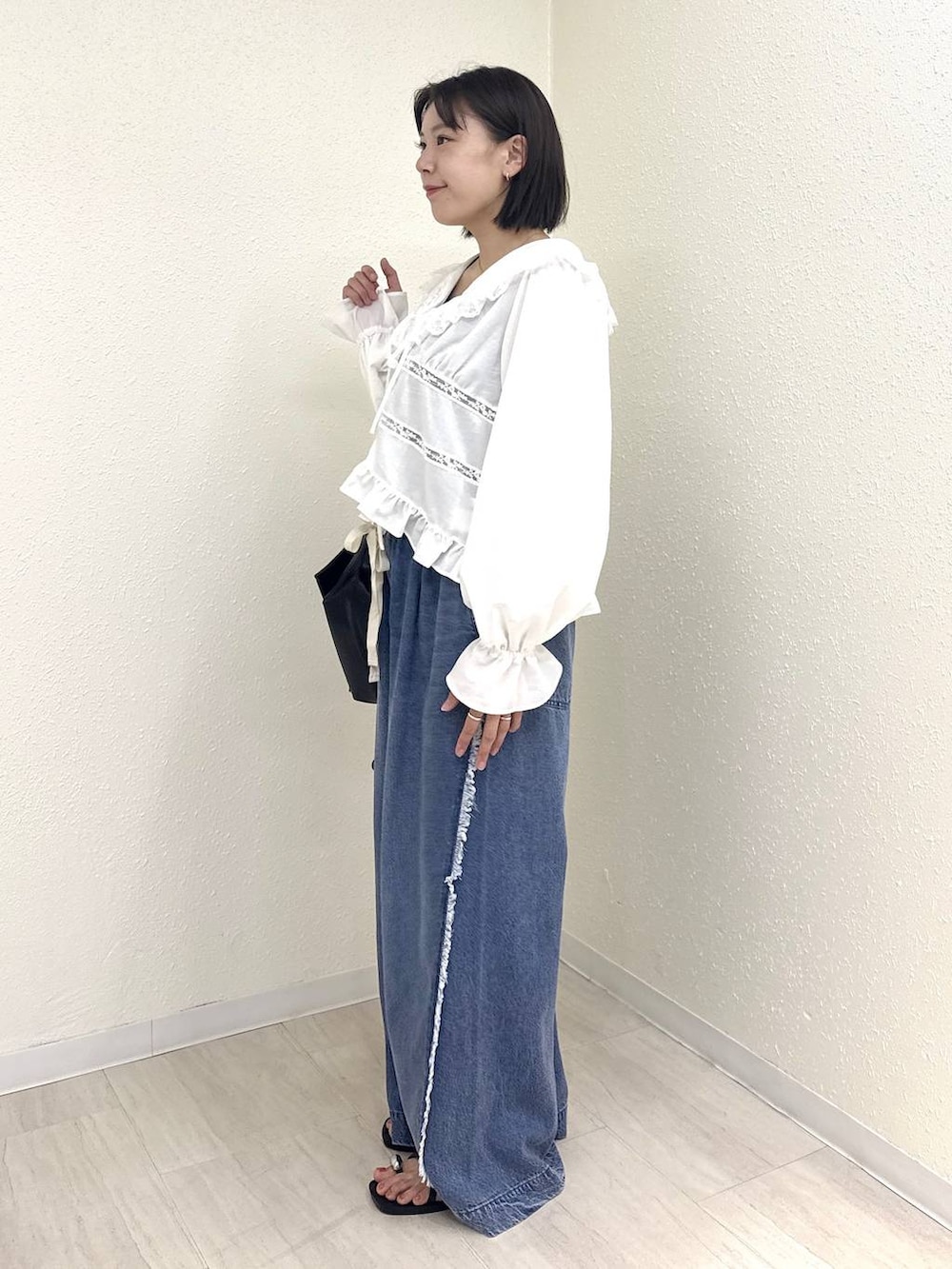 ホワイト系のシャツ/ブラウス、ブルー系のデニムパンツ、ブラック系のサンダルを着用したレディースの夏コーディネートの3枚目の写真