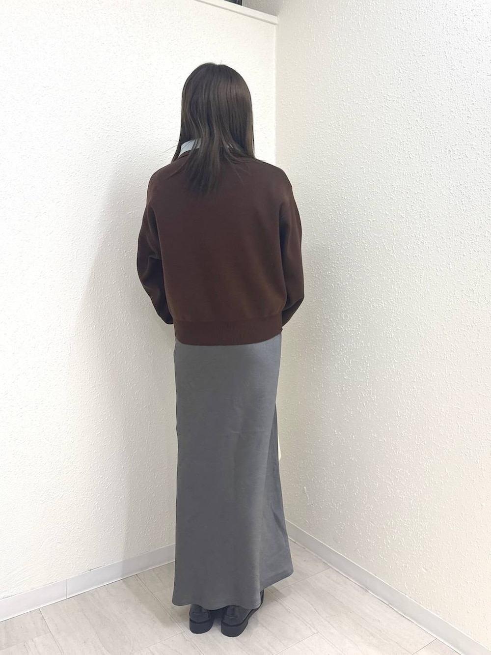 グレー系のスカート、ブラック系のローファー、ホワイト系のショルダーバッグを着用したレディースの冬コーディネートの3枚目の写真