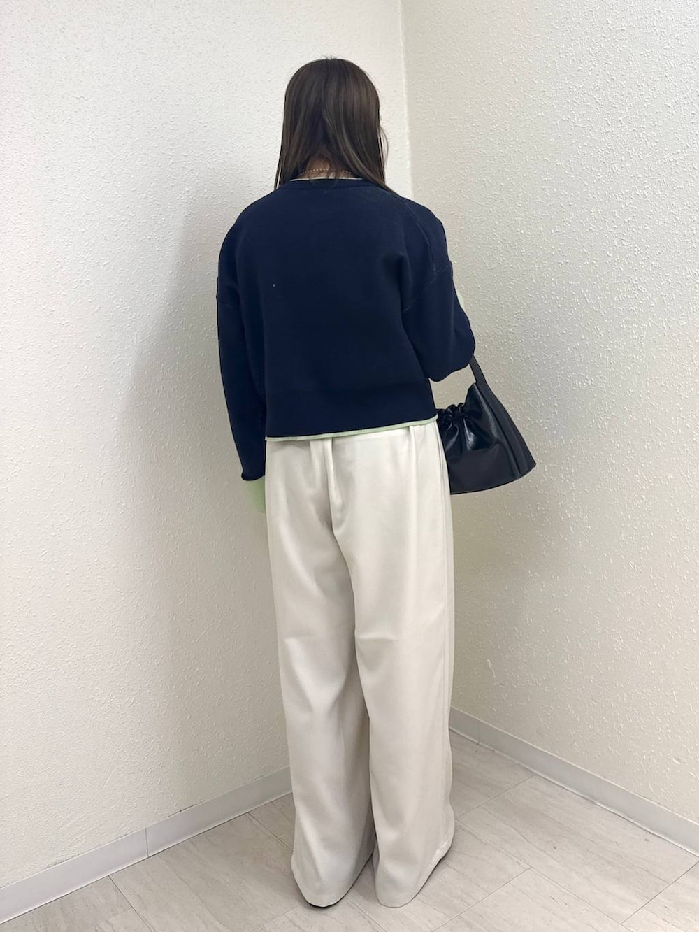 ホワイト系のその他パンツ、ブラック系のショルダーバッグ、ブラック系のモカシン/デッキシューズを着用したレディースの冬コーディネートの3枚目の写真