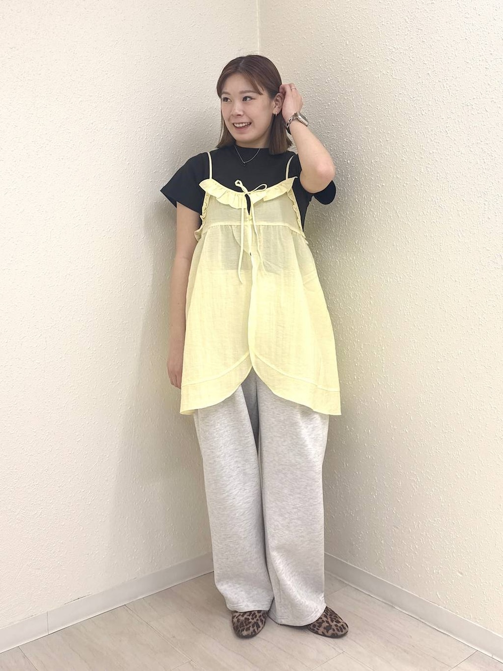 グレー系のスウェットパンツ、ブラック系のTシャツ/カットソー、イエロー系のキャミソールを着用したレディースの春コーディネートの3枚目の写真