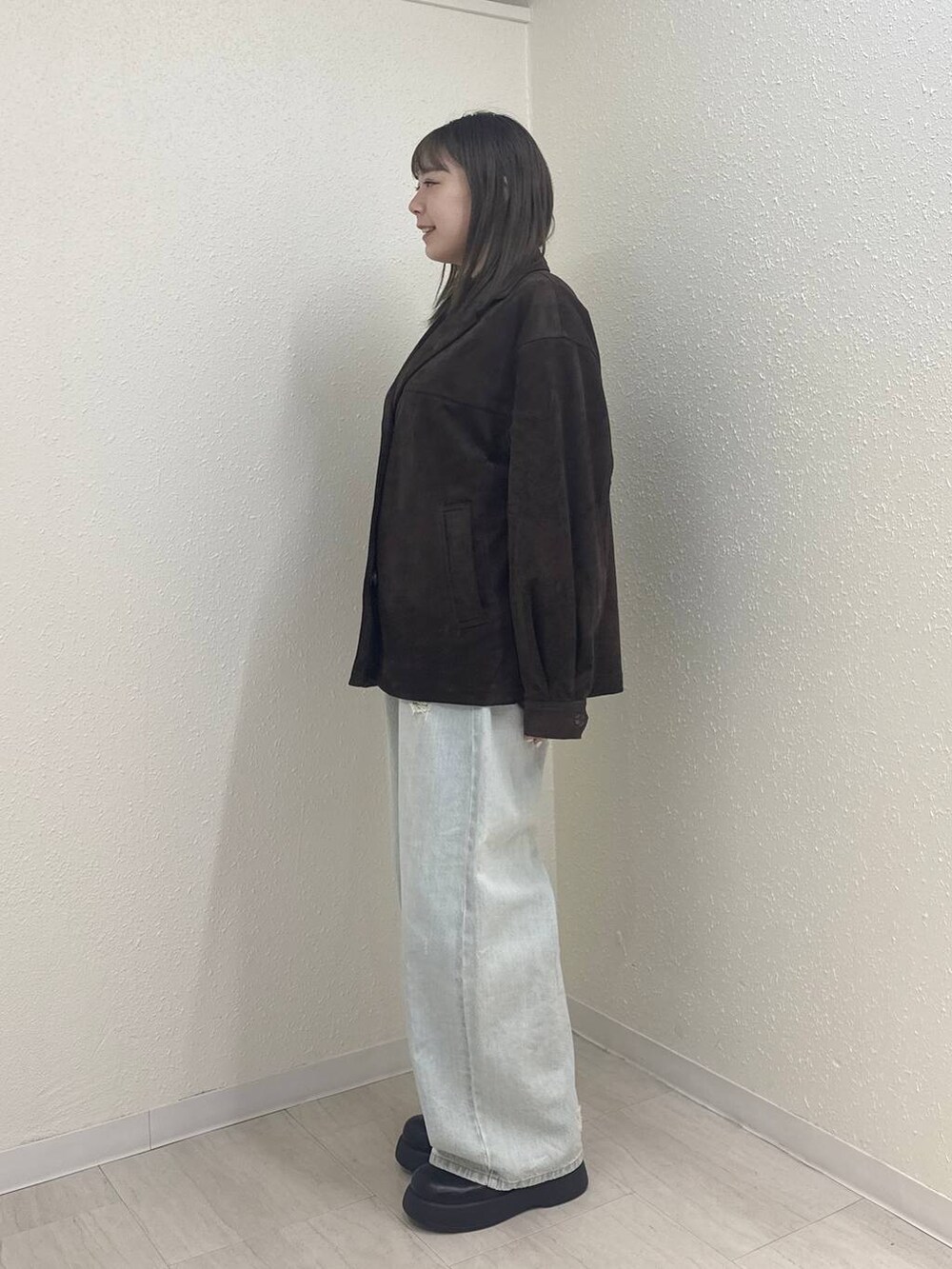 ホワイト系のTシャツ/カットソー、ブルー系のデニムパンツ、ブラック系のサンダルを着用したレディースの冬コーディネートの3枚目の写真