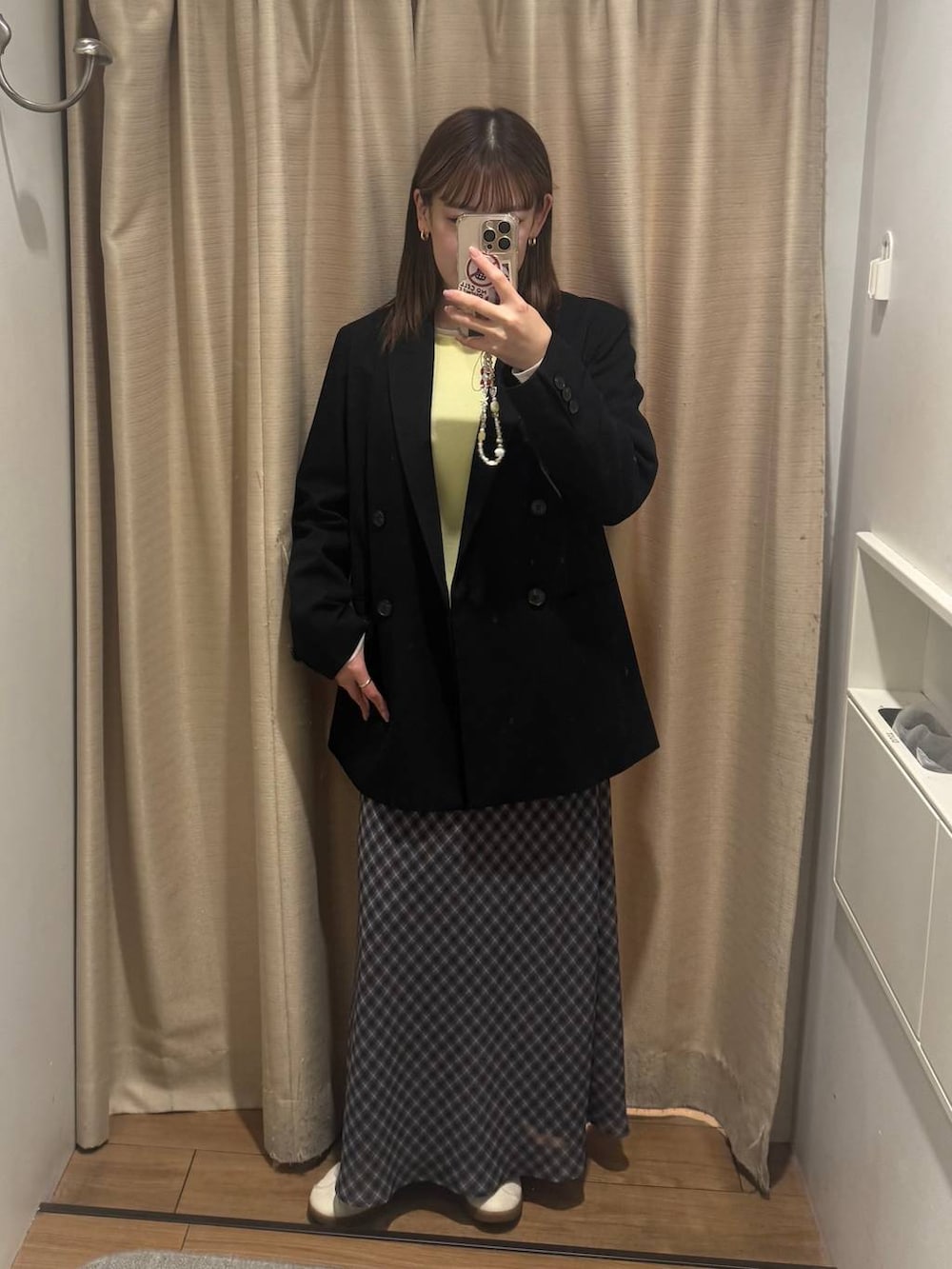 ブラック系のテーラードジャケット、グレー系のスカート、イエロー系のTシャツ/カットソーを着用したレディースの春コーディネートの2枚目の写真