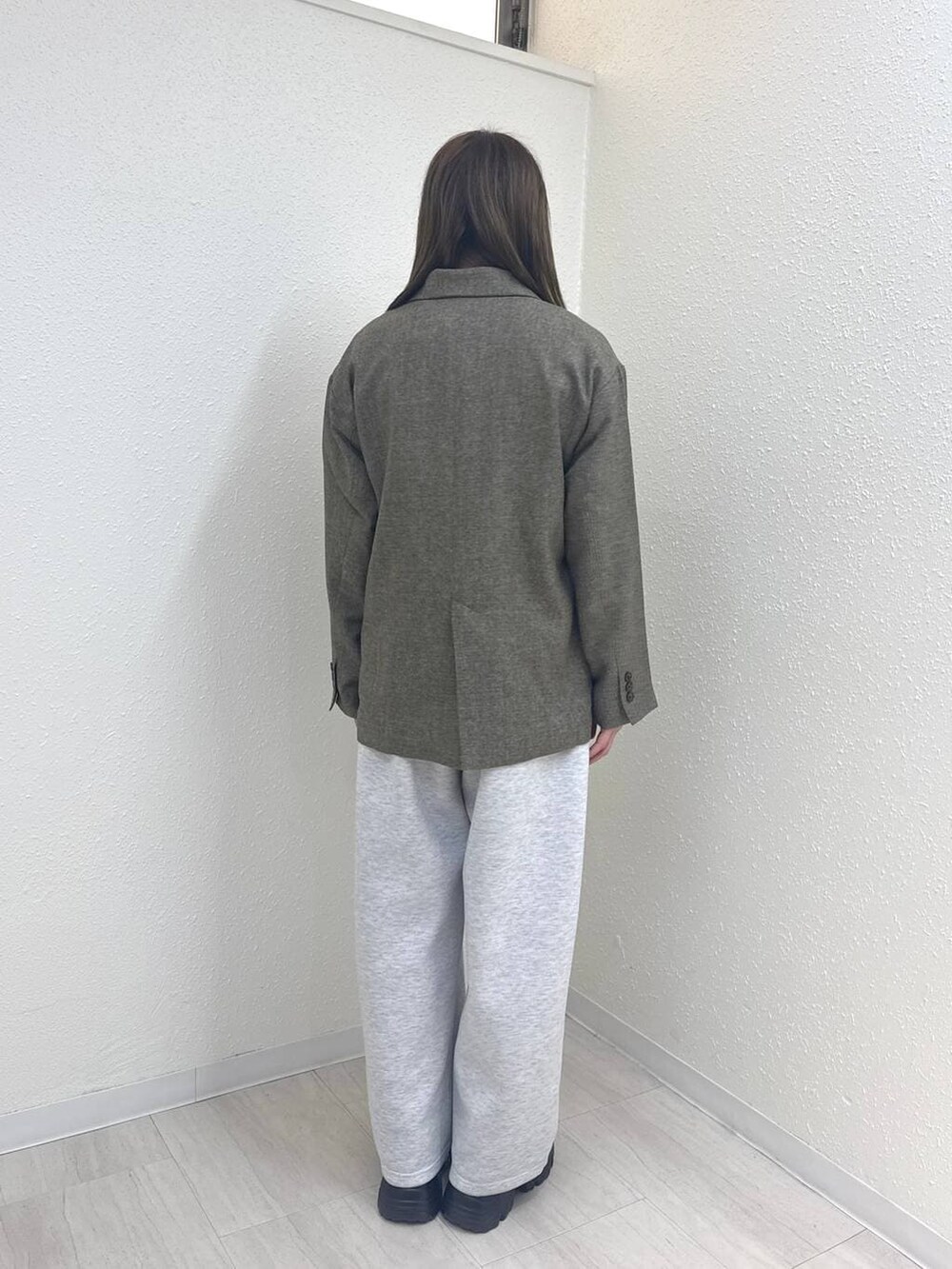 グレー系のスウェットパンツ、グレー系のテーラードジャケット、ブラウン系のローファーを着用したレディースの冬コーディネートの4枚目の写真