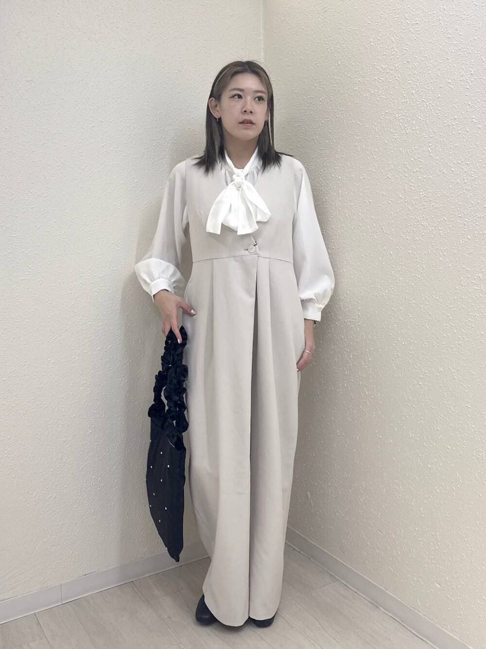 ブラック系のブーツ、ホワイト系のつなぎ/オールインワン、ホワイト系のシャツ/ブラウスを着用したレディースの冬コーディネートの2枚目の写真