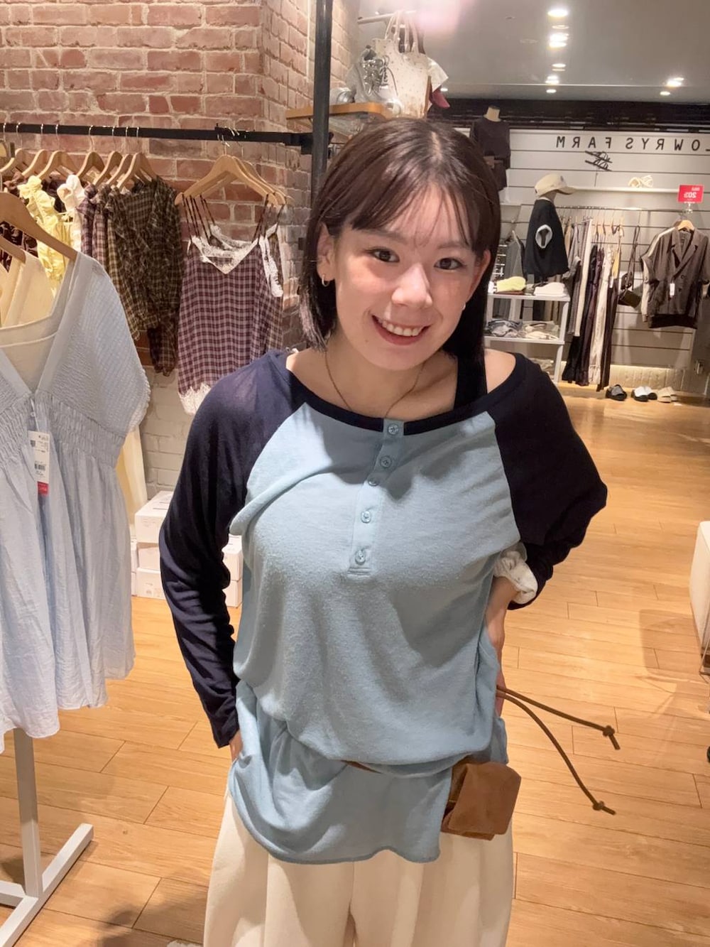 イエロー系のボディバッグ/ウエストポーチ、ブルー系のTシャツ/カットソー、ベージュ系のスウェットパンツを着用したレディースの夏コーディネートの3枚目の写真