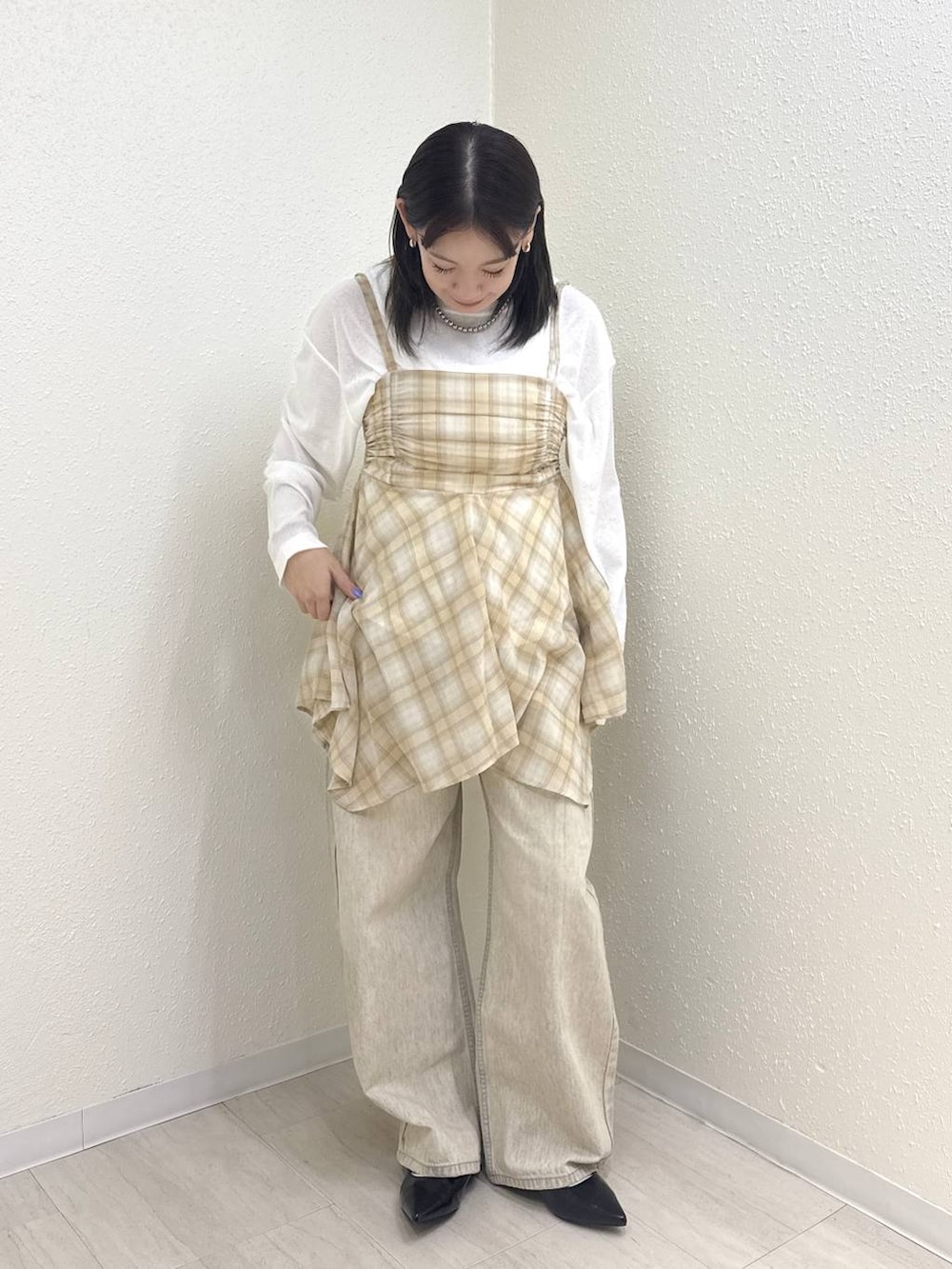 ホワイト系のTシャツ/カットソー、ブラック系のパンプス、ベージュ系のデニムパンツを着用したレディースの春コーディネートの4枚目の写真