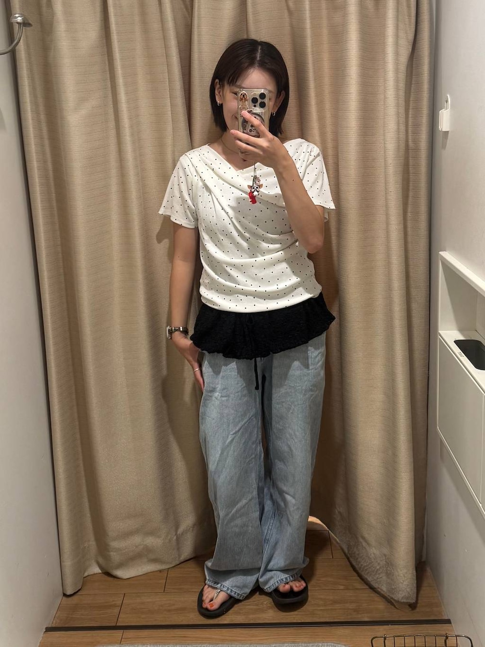 ベージュ系のTシャツ/カットソー、ブルー系のデニムパンツ、ブラック系のキャミソールを着用したレディースの秋コーディネートの3枚目の写真