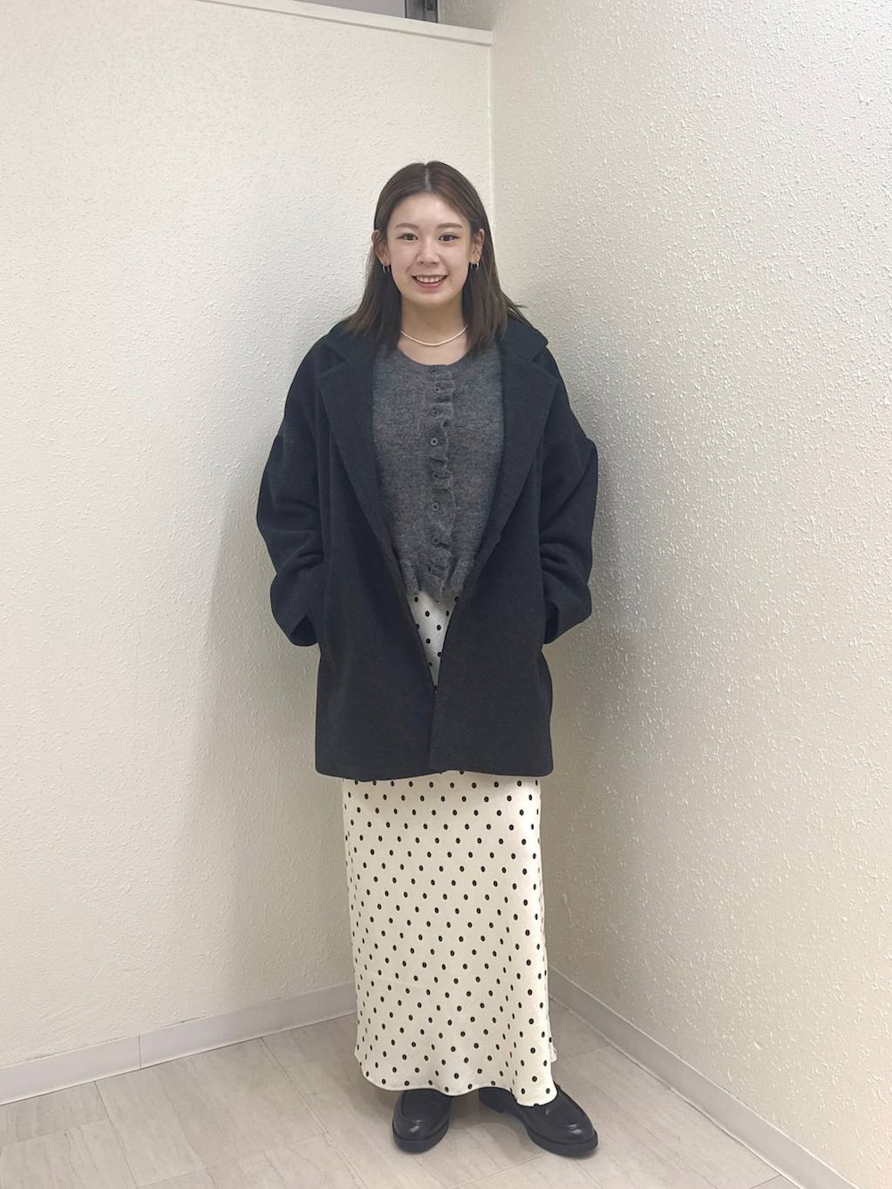 ホワイト系のスカート、グレー系のその他アウター、ブラック系のローファーを着用したレディースの冬コーディネートの3枚目の写真