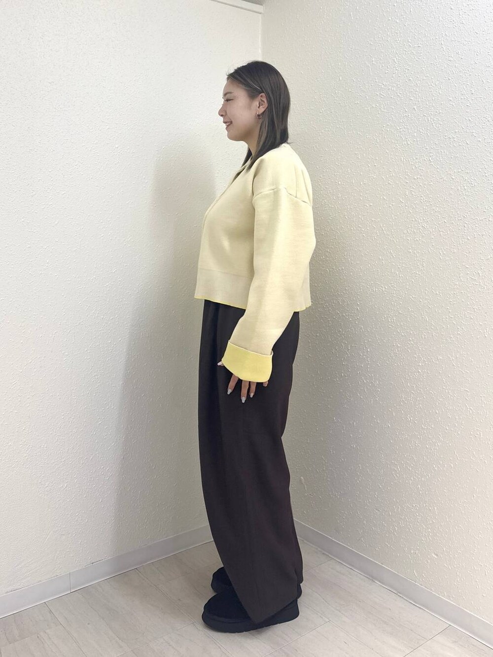 ブラウン系のその他パンツ、ブラック系のブーツ、ホワイト系のカーディガン/ボレロを着用したレディースの冬コーディネートの2枚目の写真