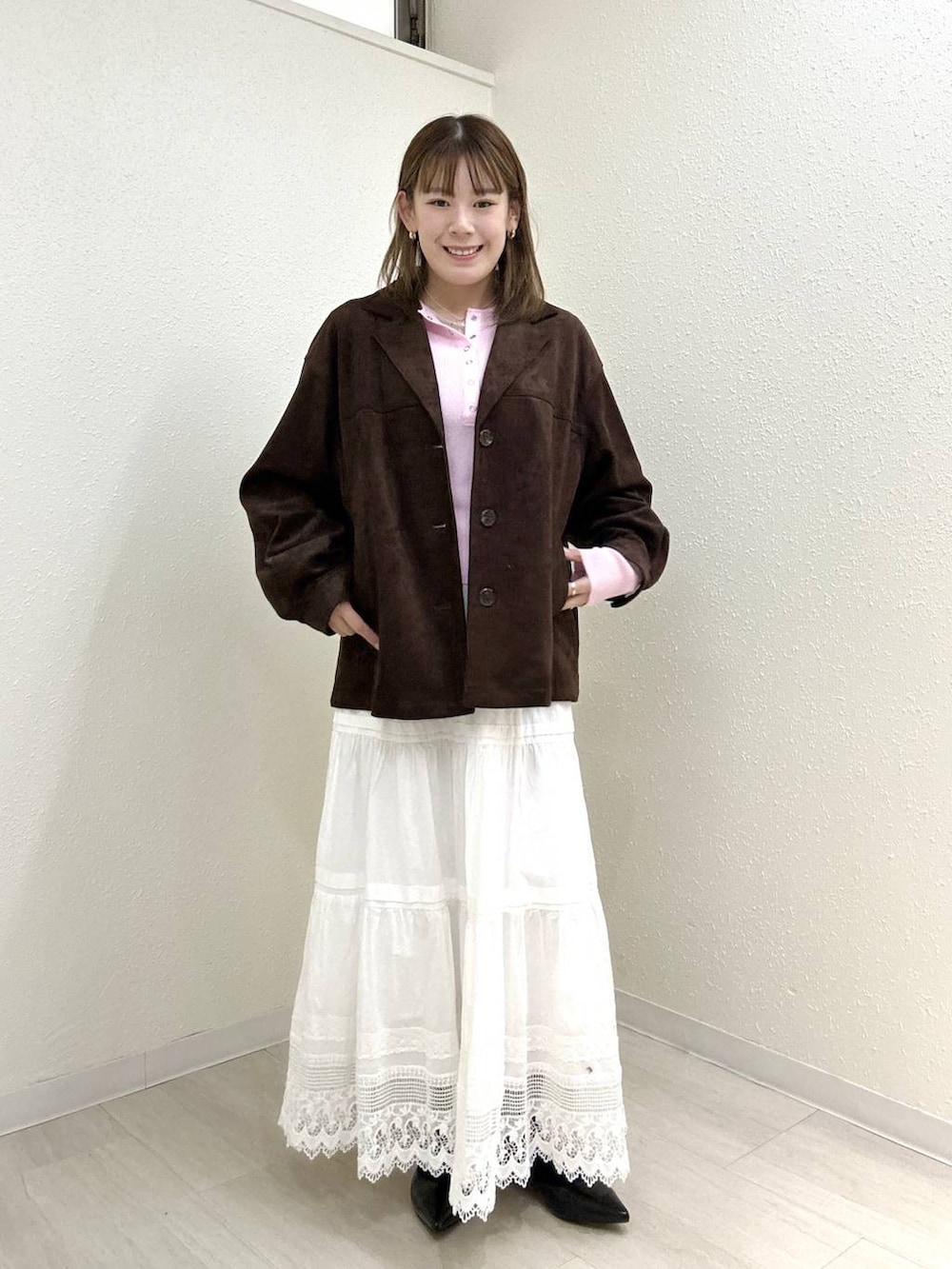 ブラック系のパンプス、ピンク系のニット/セーター、ブラウン系のテーラードジャケットを着用したレディースの春コーディネートの2枚目の写真