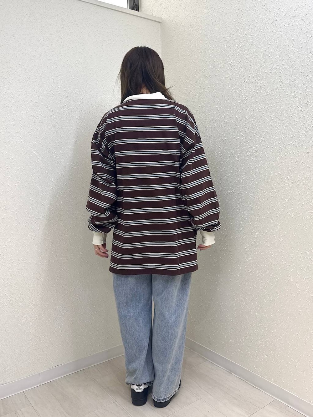 ブルー系のデニムパンツ、ブラウン系のTシャツ/カットソーを着用したレディースの春コーディネートの2枚目の写真