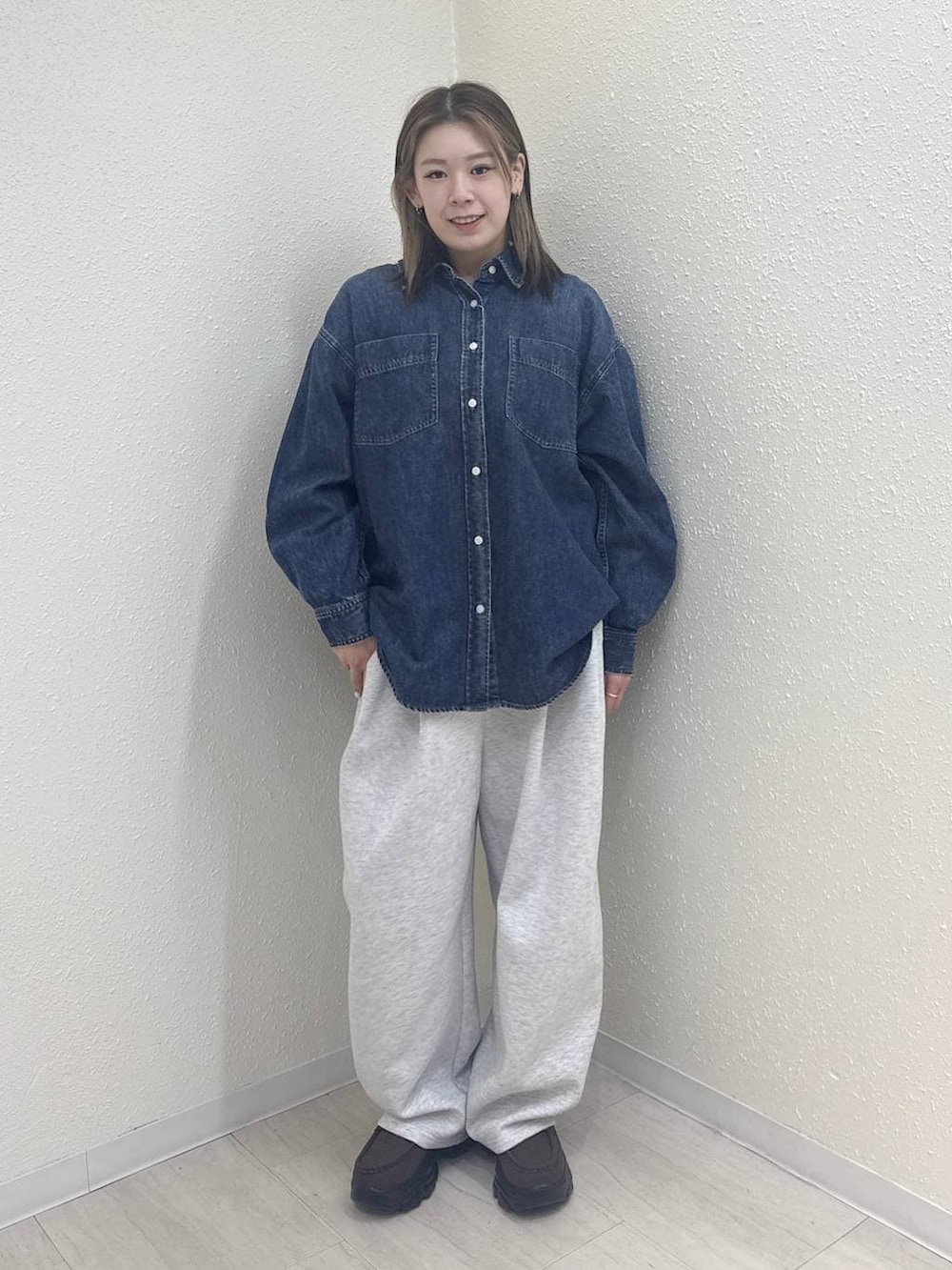 グレー系のスウェットパンツ、ブルー系のシャツ/ブラウス、ブラウン系のローファーを着用したレディースの冬コーディネートの2枚目の写真