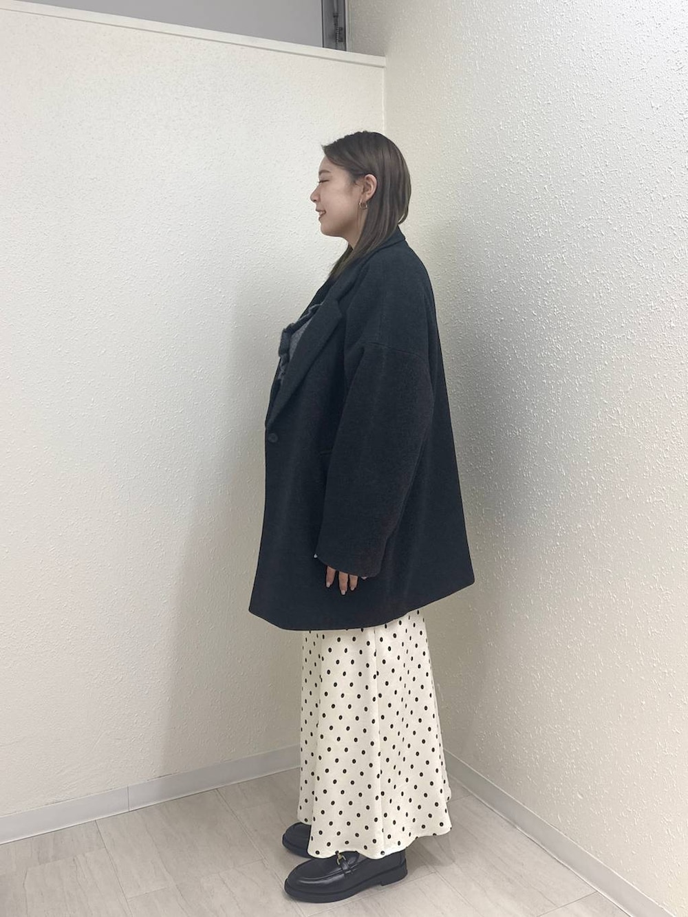 ホワイト系のスカート、グレー系のその他アウター、ブラック系のローファーを着用したレディースの冬コーディネートの4枚目の写真