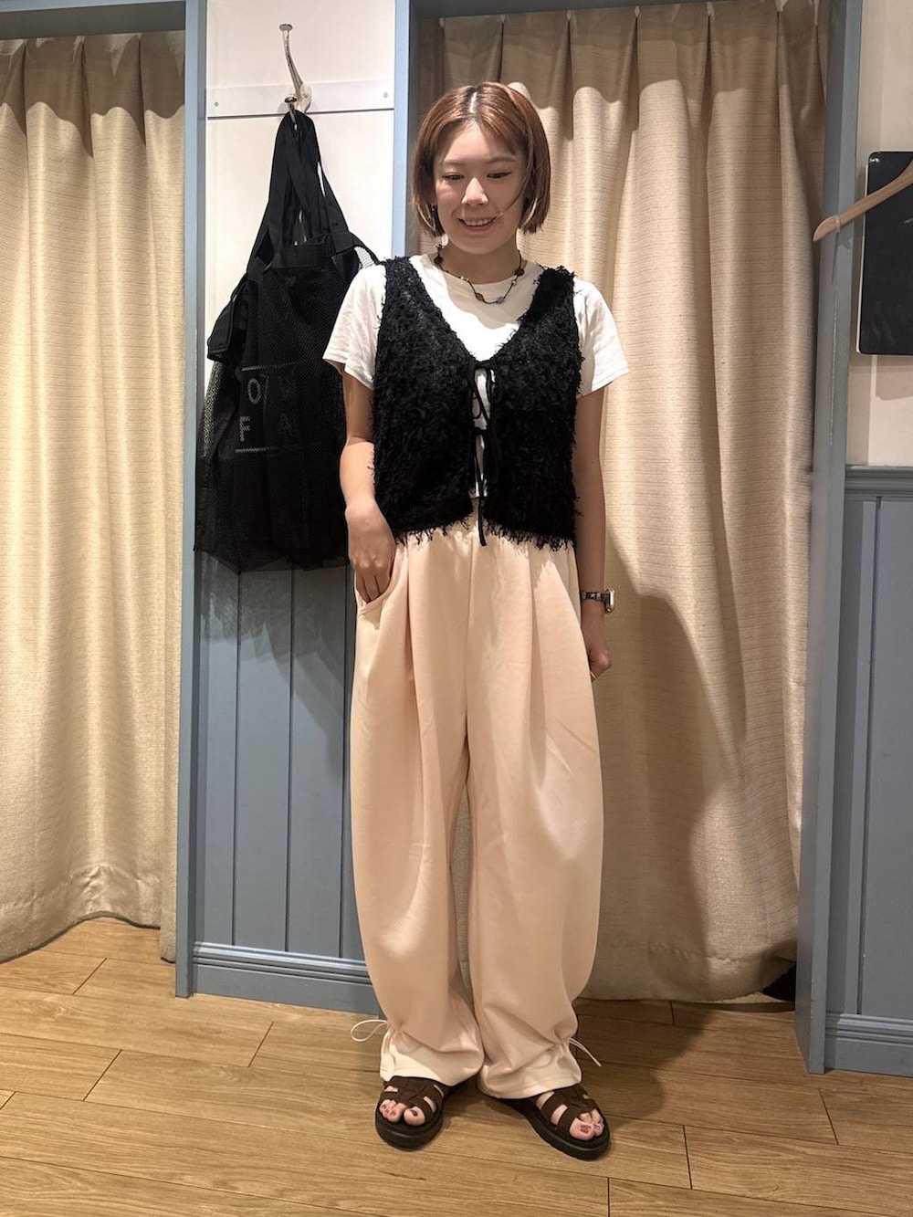 ピンク系のスウェットパンツ、ホワイト系のTシャツ/カットソー、ブラウン系のサンダルを着用したレディースの夏コーディネートの2枚目の写真