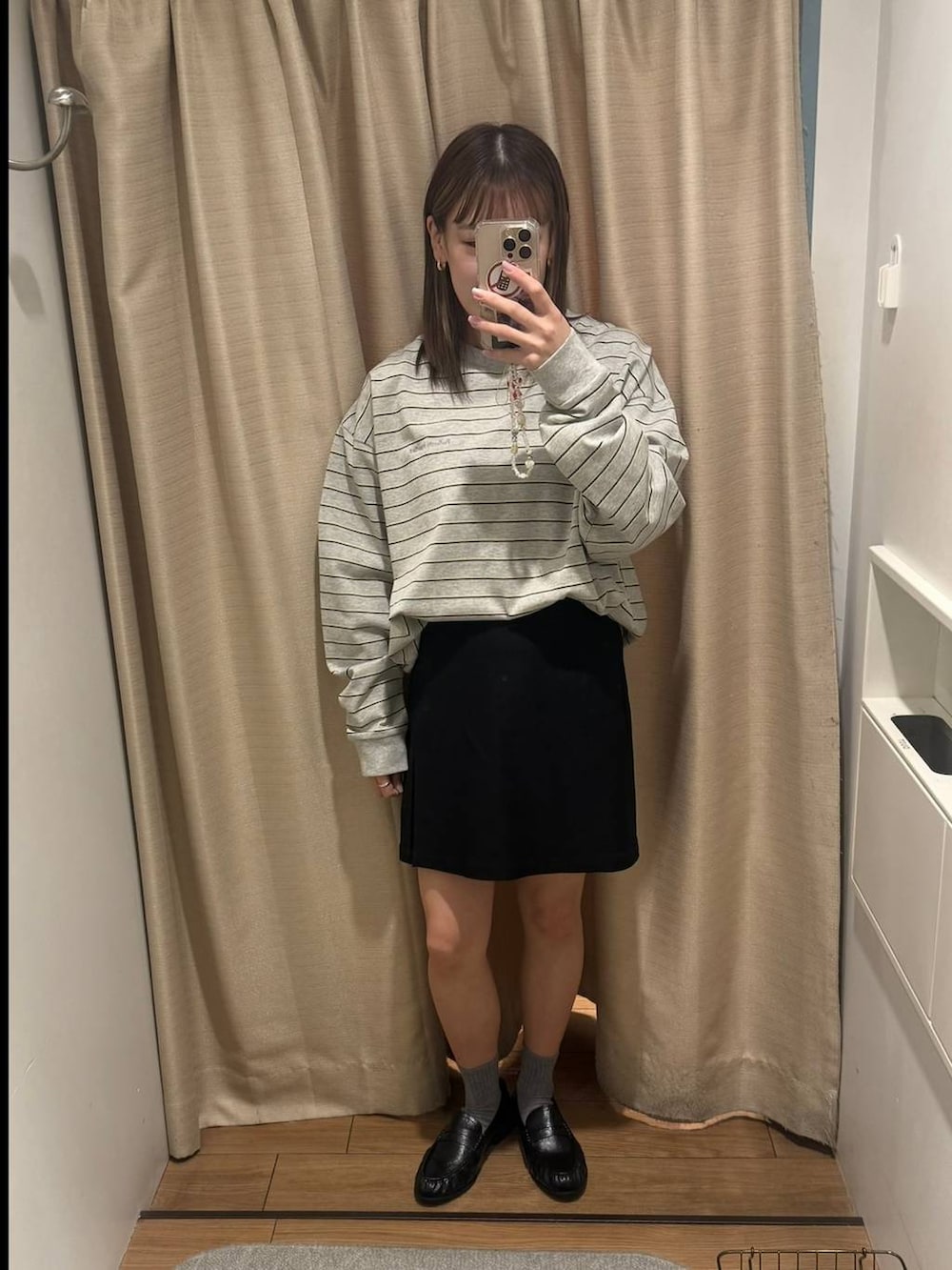 ブラック系のローファー、グレー系のTシャツ/カットソー、ブラック系のスカートを着用したレディースの春コーディネートの2枚目の写真