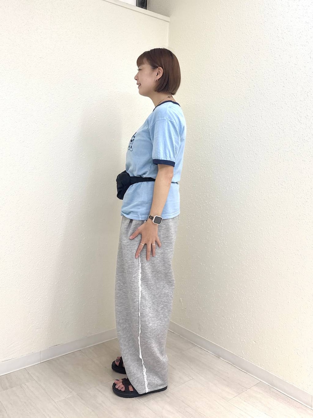 グレー系のスウェットパンツ、ブラック系のボディバッグ/ウエストポーチ、ブラウン系のサンダルを着用したレディースの夏コーディネートの3枚目の写真