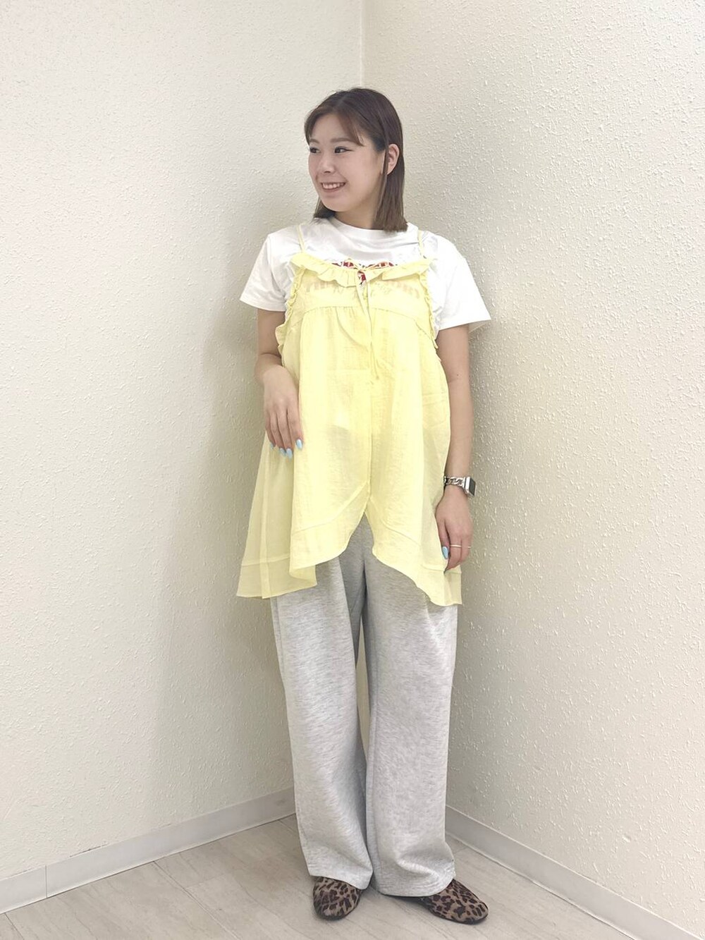 グレー系のスウェットパンツ、ホワイト系のTシャツ/カットソー、イエロー系のキャミソールを着用したレディースの春コーディネートの2枚目の写真