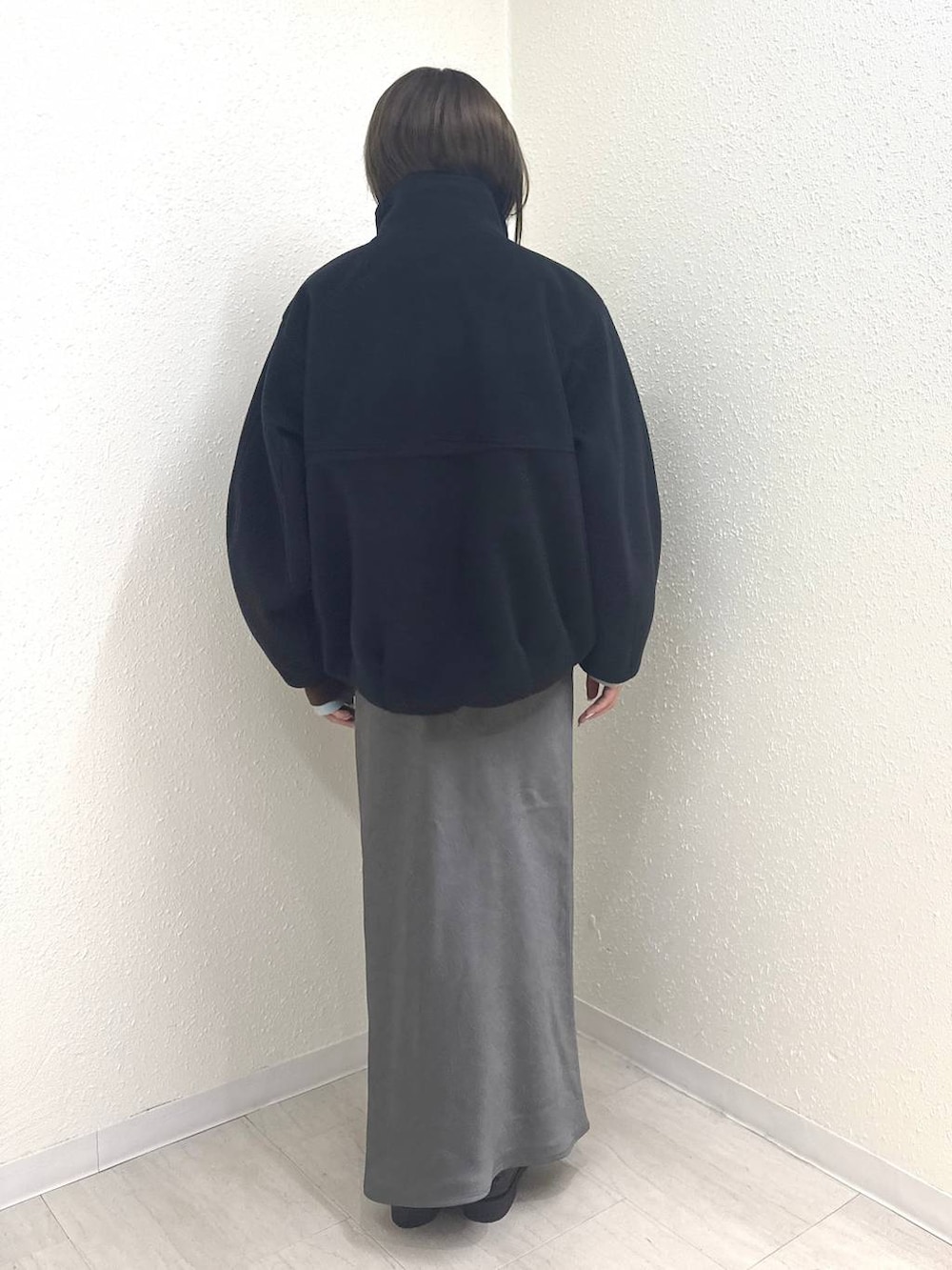 グレー系のスカート、ブラック系のローファー、ブラック系のブルゾンを着用したレディースの冬コーディネートの4枚目の写真