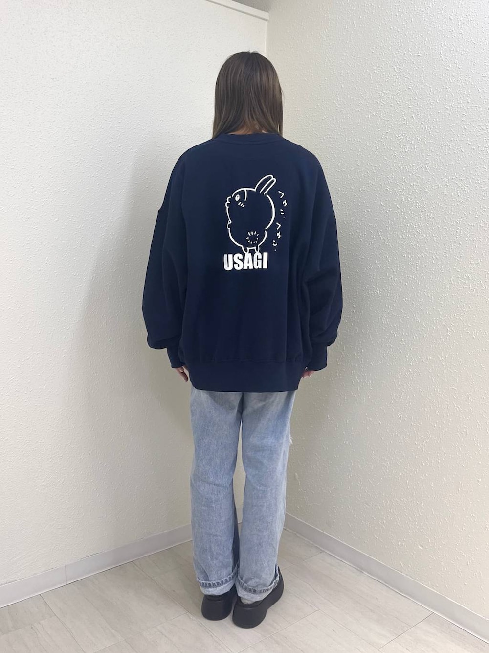 ブルー系のデニムパンツ、ブラック系のサンダル、ブルー系のスウェットを着用したレディースの冬コーディネートの2枚目の写真